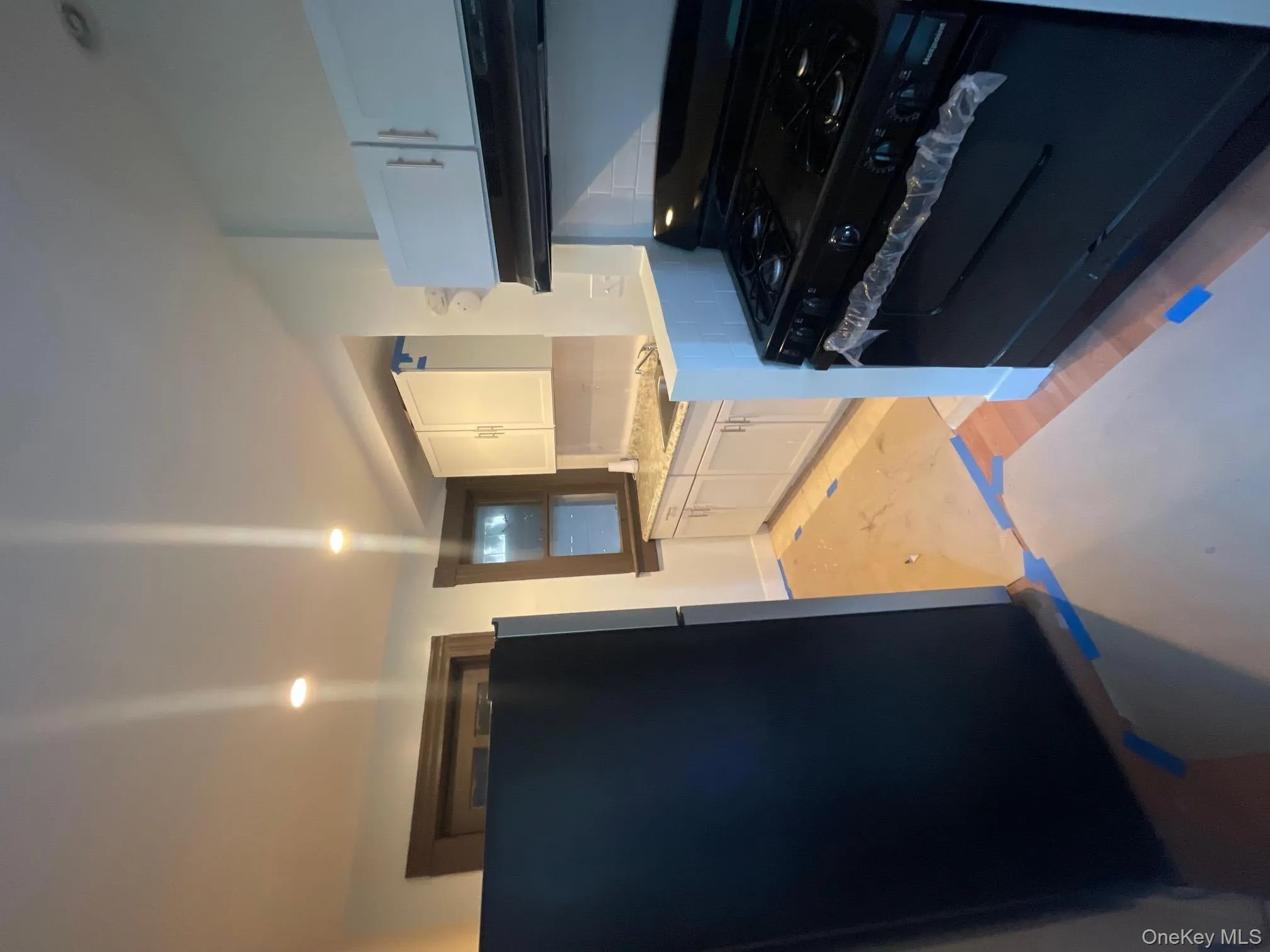 Kitchen featuring range, refrigerator, white cabinetry, range hood, and recessed lighting Kitchen featuring range, refrigerator, white cabinetry, range hood, and recessed lighting