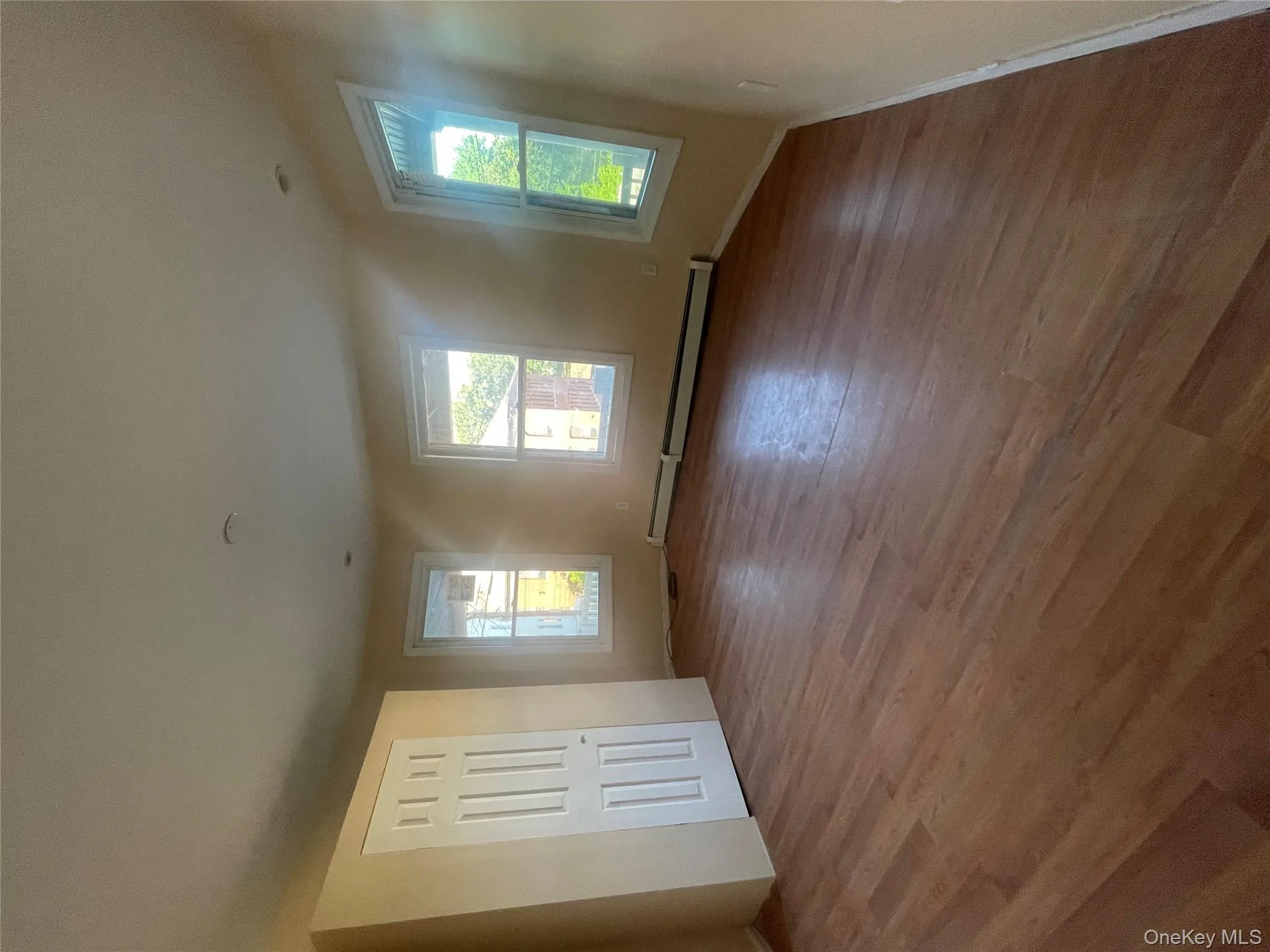 Unfurnished bedroom featuring a baseboard heating unit and light wood-type flooring Unfurnished bedroom featuring a baseboard heating unit and light wood-type flooring