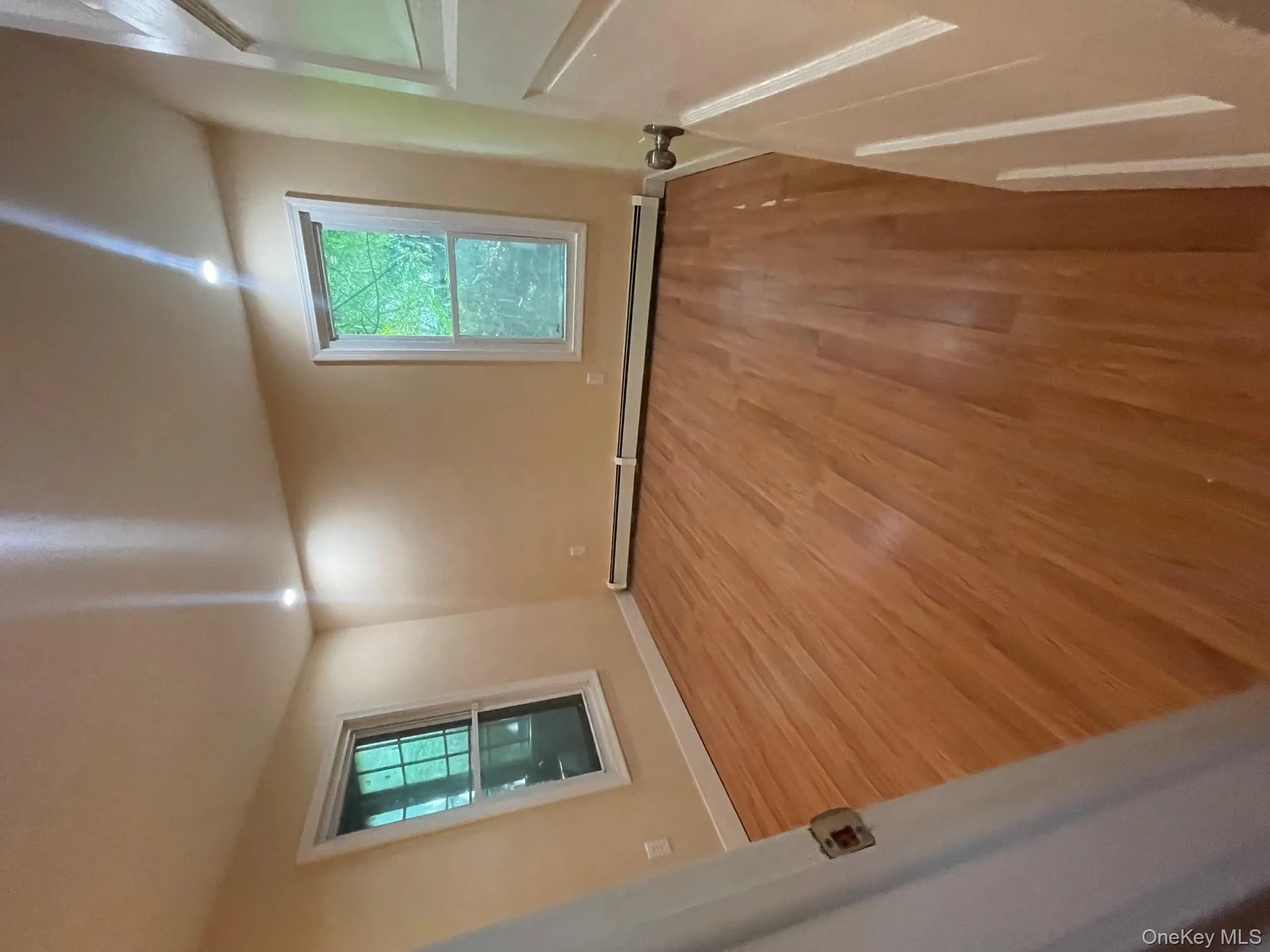 Spare room with light wood-type flooring, plenty of natural light, and baseboard heating Spare room with light wood-type flooring, plenty of natural light, and baseboard heating