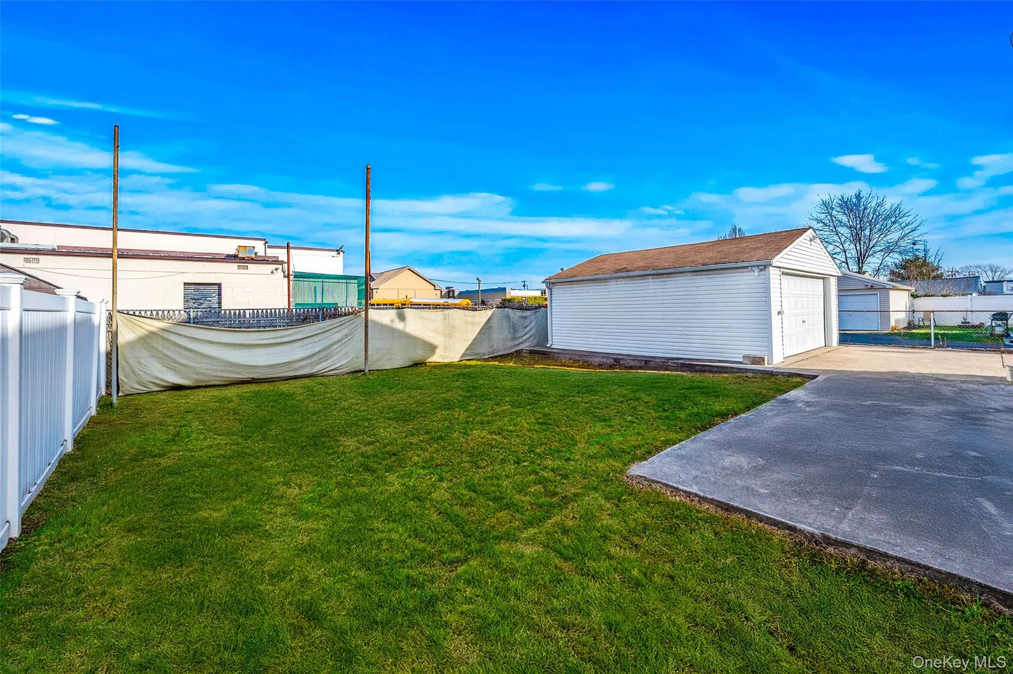 Fenced backyard featuring an outbuilding and a detached garage Fenced backyard featuring an outbuilding and a detached garage