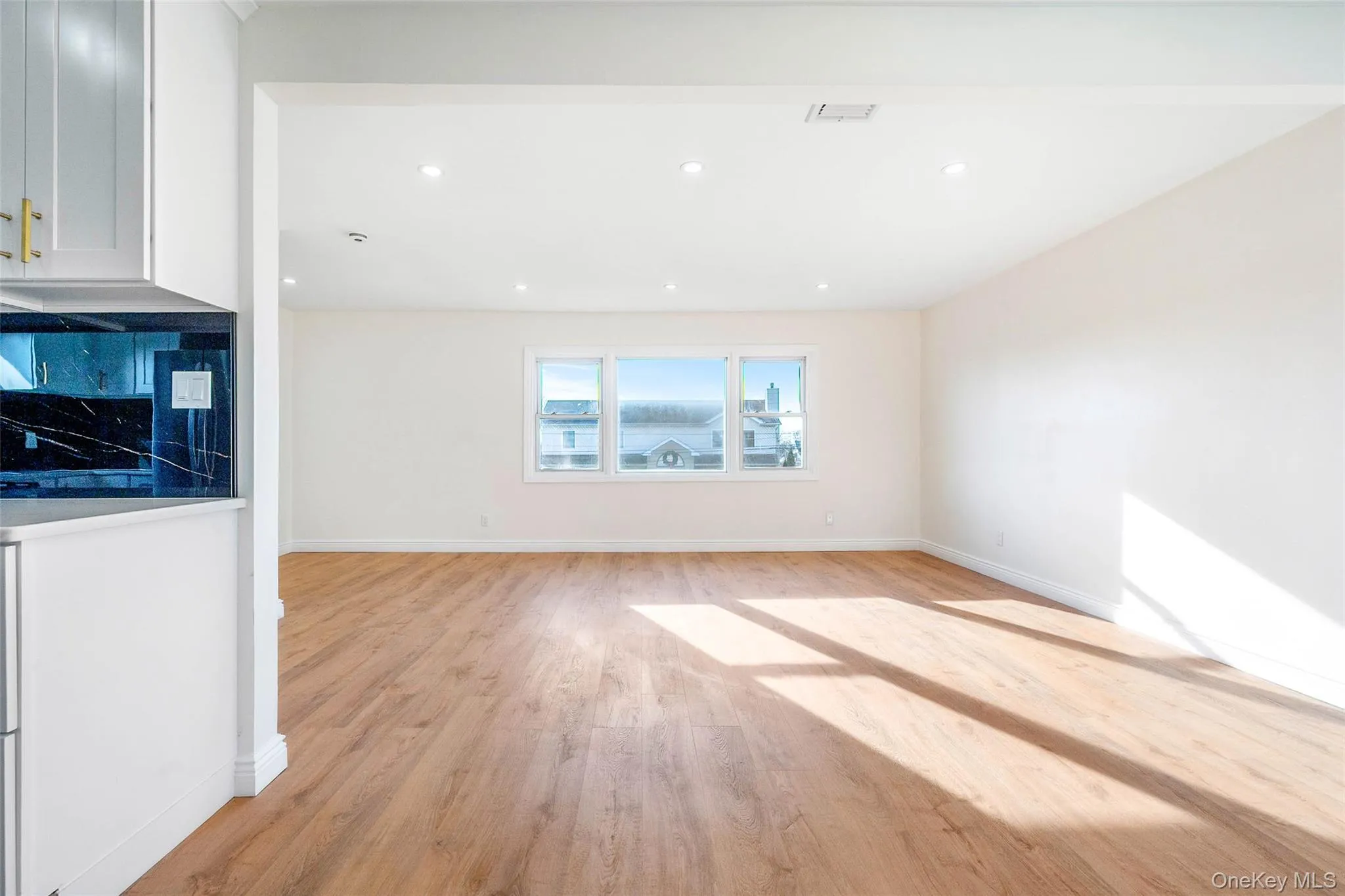 Unfurnished living room featuring light wood-style floors and recessed lighting Unfurnished living room featuring light wood-style floors and recessed lighting