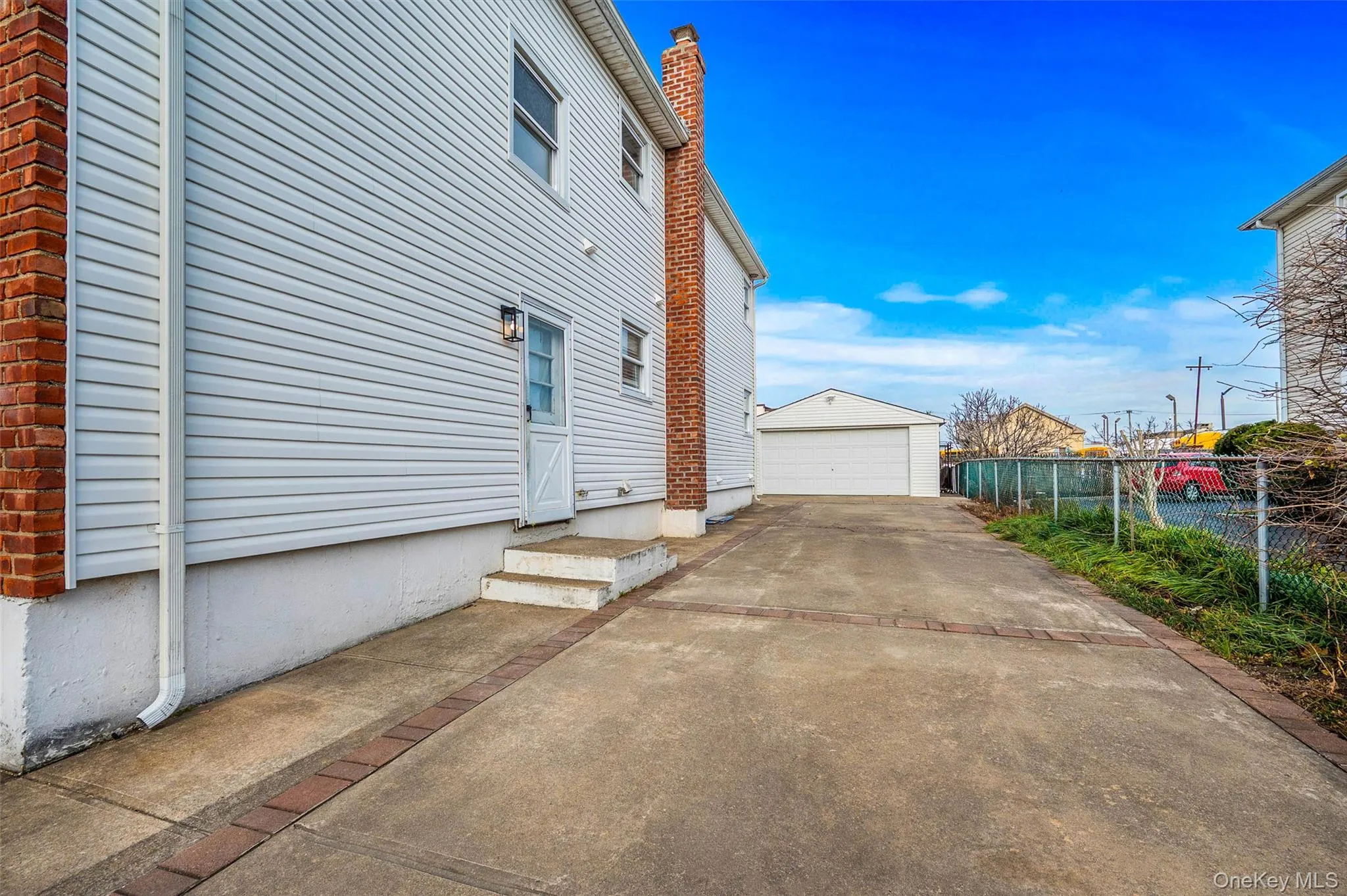 View of side of home featuring an outbuilding, a garage, and a chimney View of side of home featuring an outbuilding, a garage, and a chimney