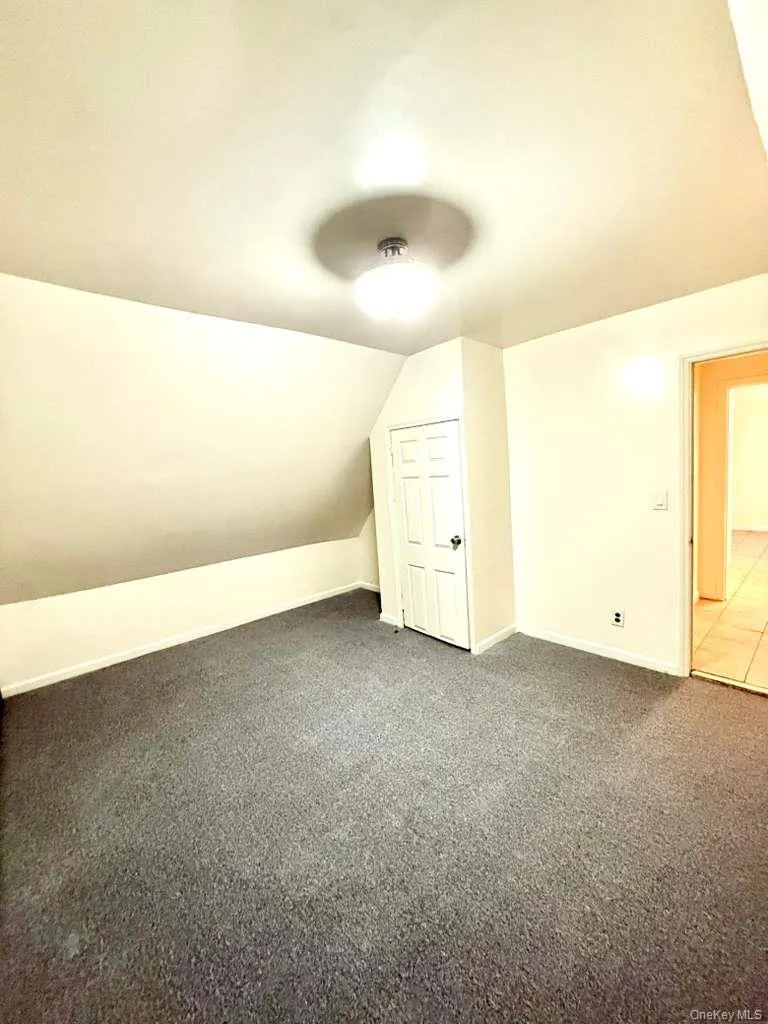 Bonus room with vaulted ceiling and carpet Bonus room with vaulted ceiling and carpet