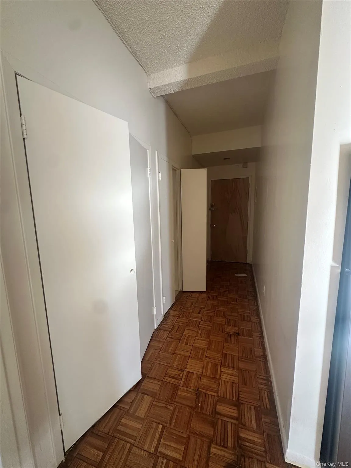 Hall with a textured ceiling and baseboards Hall with a textured ceiling and baseboards