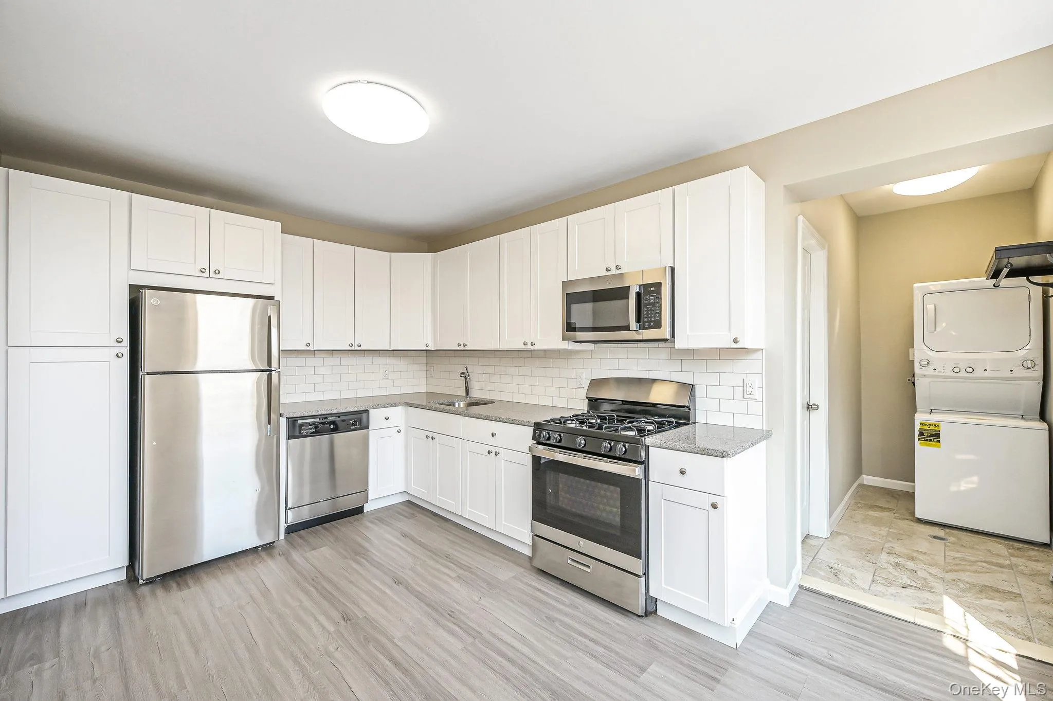 Kitchen with stainless steel appliances, stacked washer and clothes dryer Kitchen with stainless steel appliances, stacked washer and clothes dryer