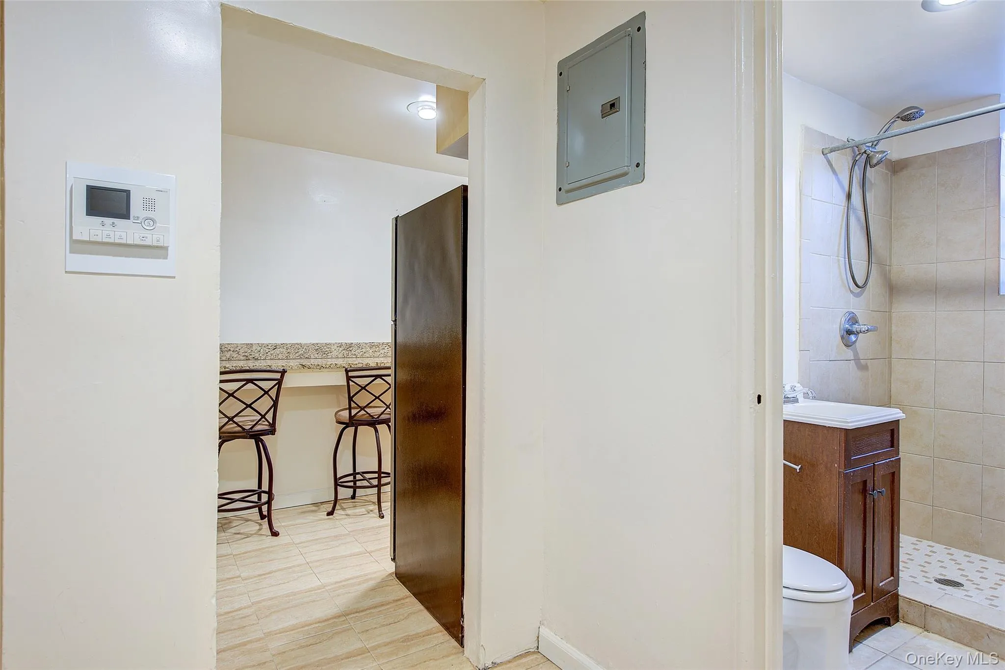 Full bathroom featuring a stall shower, electric panel, light tile patterned floors, and vanity Full bathroom featuring a stall shower, electric panel, light tile patterned floors, and vanity