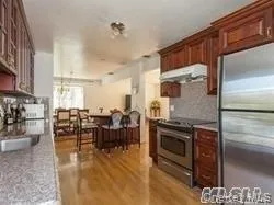 Kitchen with appliances with stainless steel finishes, decorative backsplash, under cabinet range hood, and light countertops Kitchen with appliances with stainless steel finishes, decorative backsplash, under cabinet range hood, and light countertops