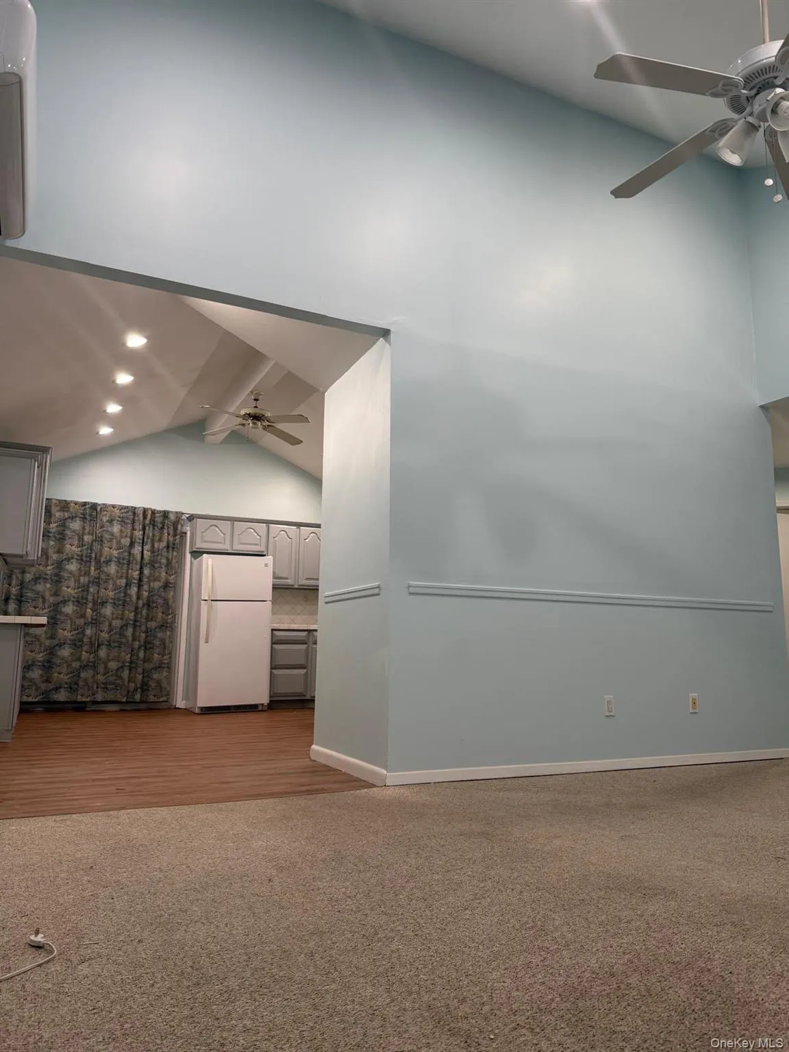 Empty room with a ceiling fan, light wood finished floors, light colored carpet, and recessed lighting Empty room with a ceiling fan, light wood finished floors, light colored carpet, and recessed lighting