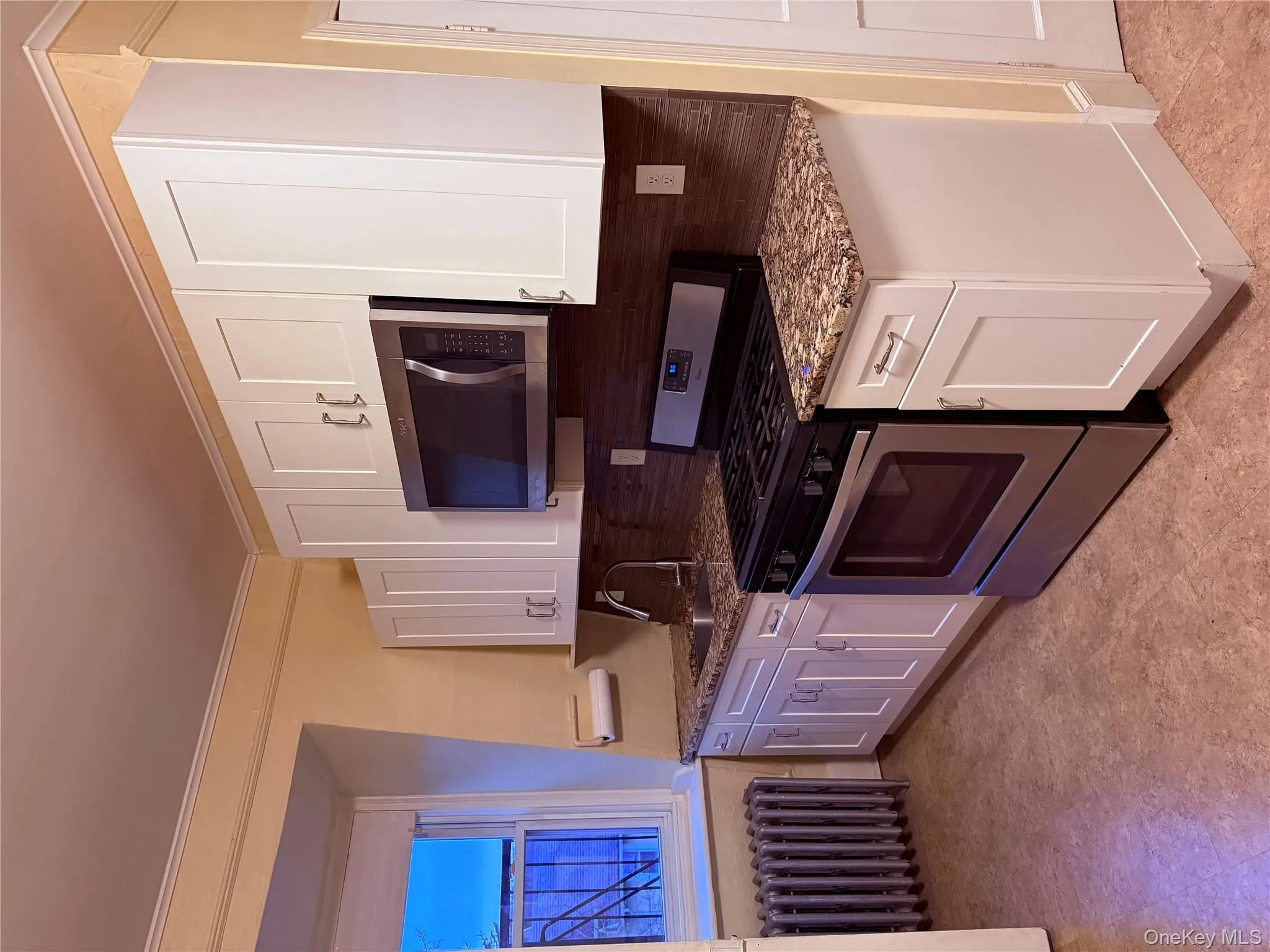 Kitchen with Stainless Gas stove, stainless steel microwave, dark stone countertops, and white cabinets Kitchen with Stainless Gas stove, stainless steel microwave, dark stone countertops, and white cabinets