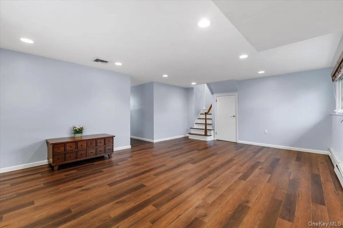 Below grade area featuring stairway, recessed lighting, and dark wood finished floors Below grade area featuring stairway, recessed lighting, and dark wood finished floors