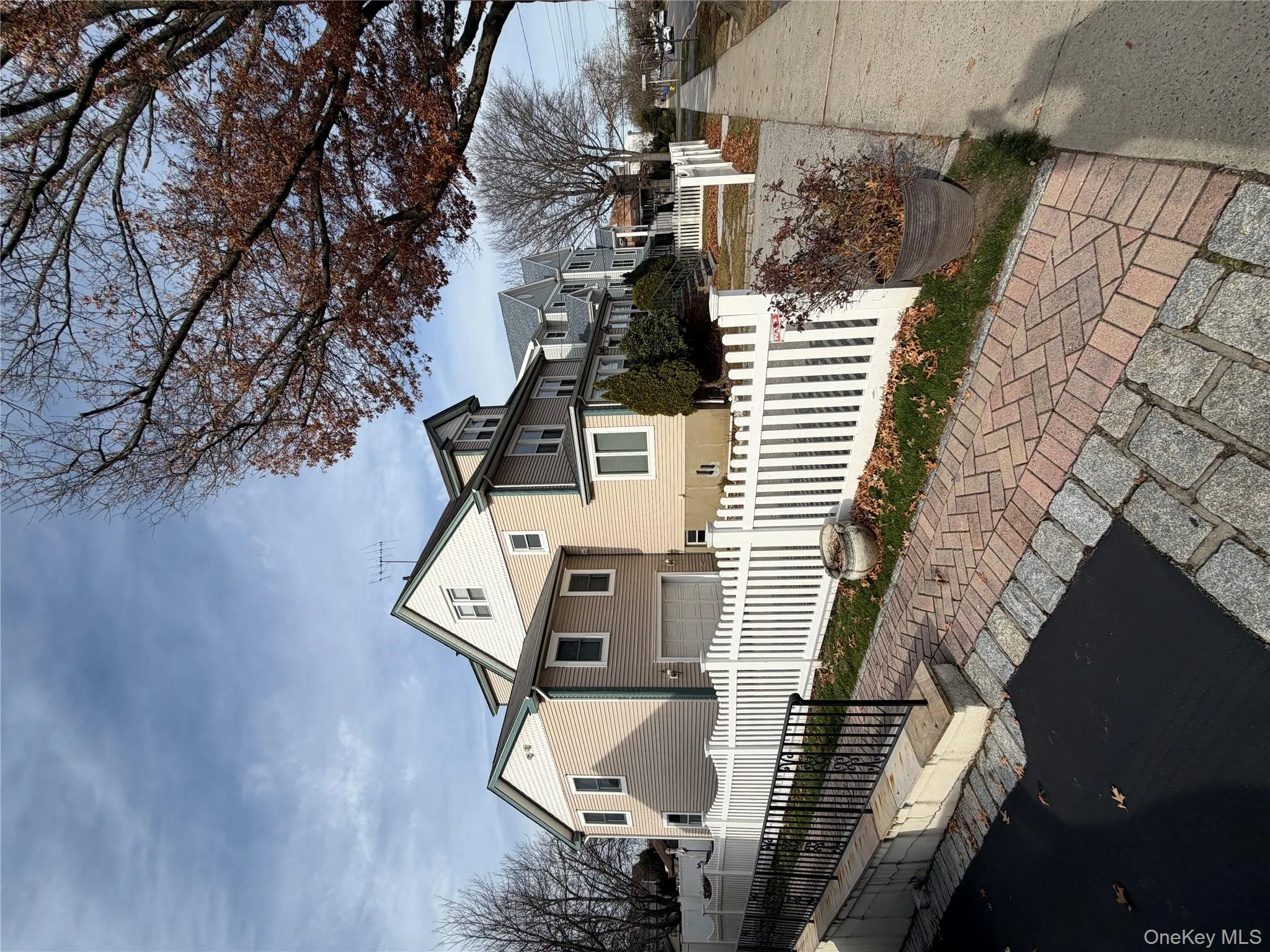View of side of home featuring a fenced front yard, a garage, and a residential view View of side of home featuring a fenced front yard, a garage, and a residential view