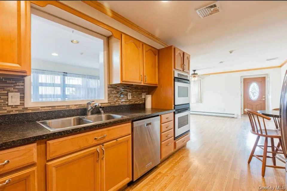 Kitchen with plenty of natural light, stainless steel appliances, tasteful backsplash, light wood finished floors, and recessed lighting Kitchen with plenty of natural light, stainless steel appliances, tasteful backsplash, light wood finished floors, and recessed lighting