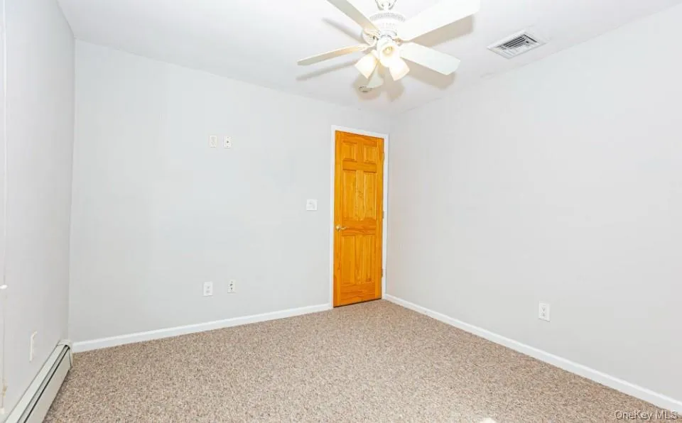 Carpeted spare room featuring a baseboard heating unit and ceiling fan Carpeted spare room featuring a baseboard heating unit and ceiling fan
