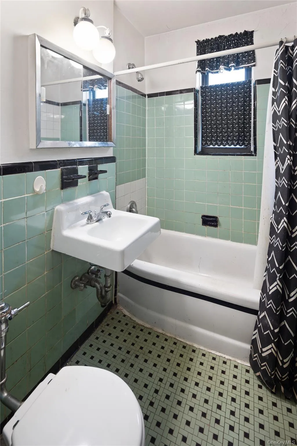 Bathroom with shower / tub combo with curtain, tile walls, and tile patterned floors Bathroom with shower / tub combo with curtain, tile walls, and tile patterned floors