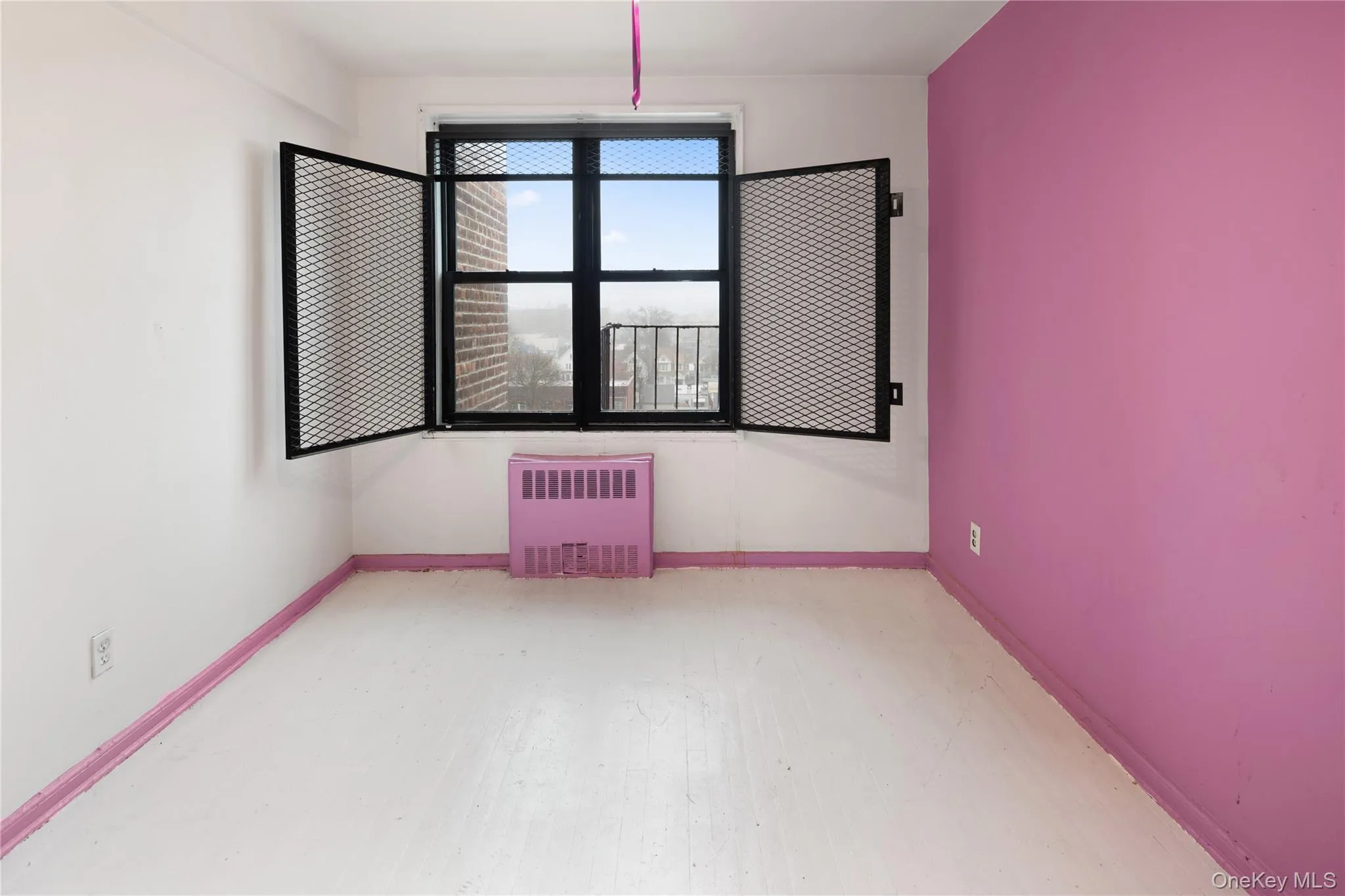 Unfurnished room with radiator and baseboards Unfurnished room with radiator and baseboards