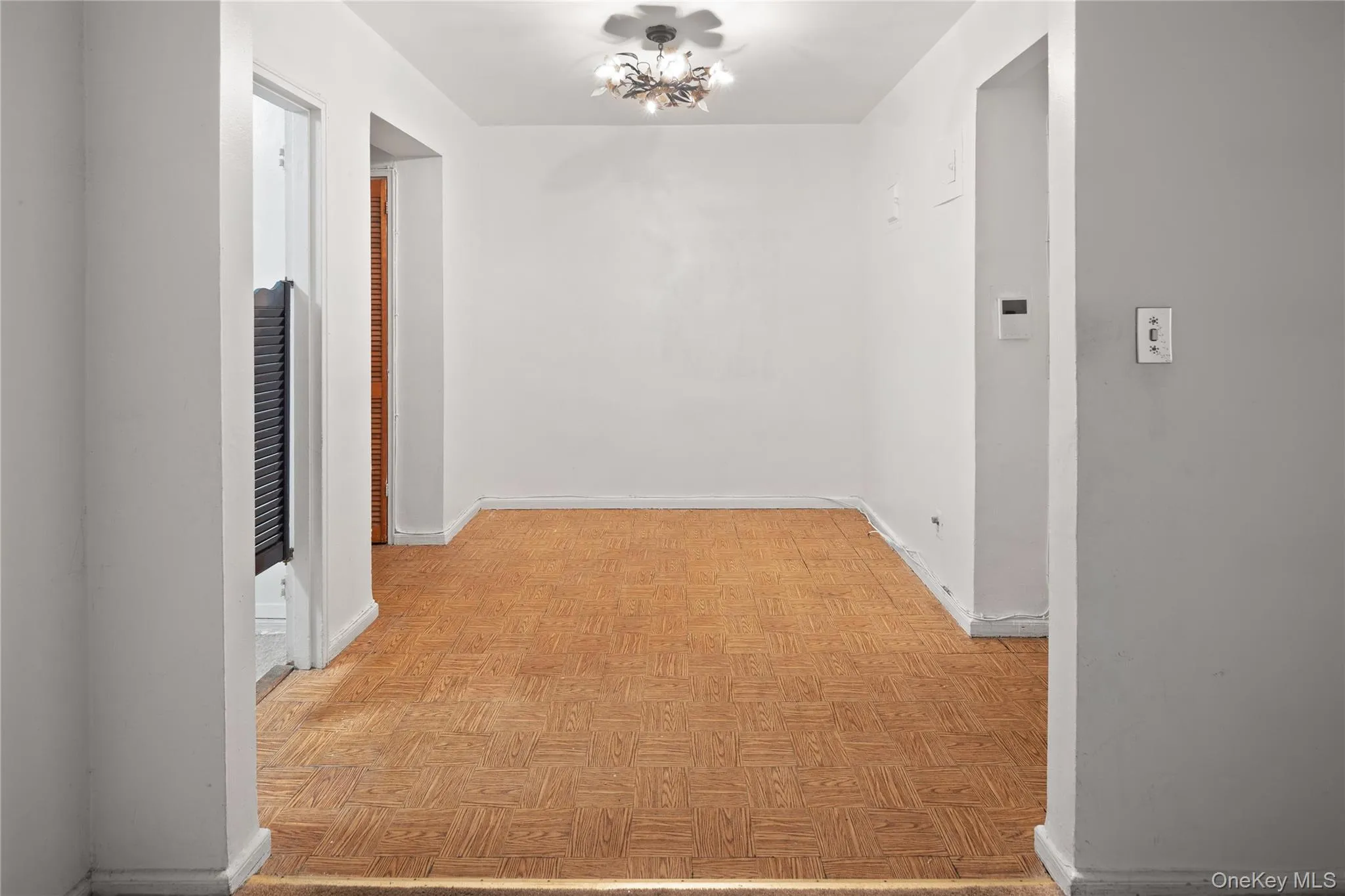 Hall featuring a chandelier and baseboards Hall featuring a chandelier and baseboards