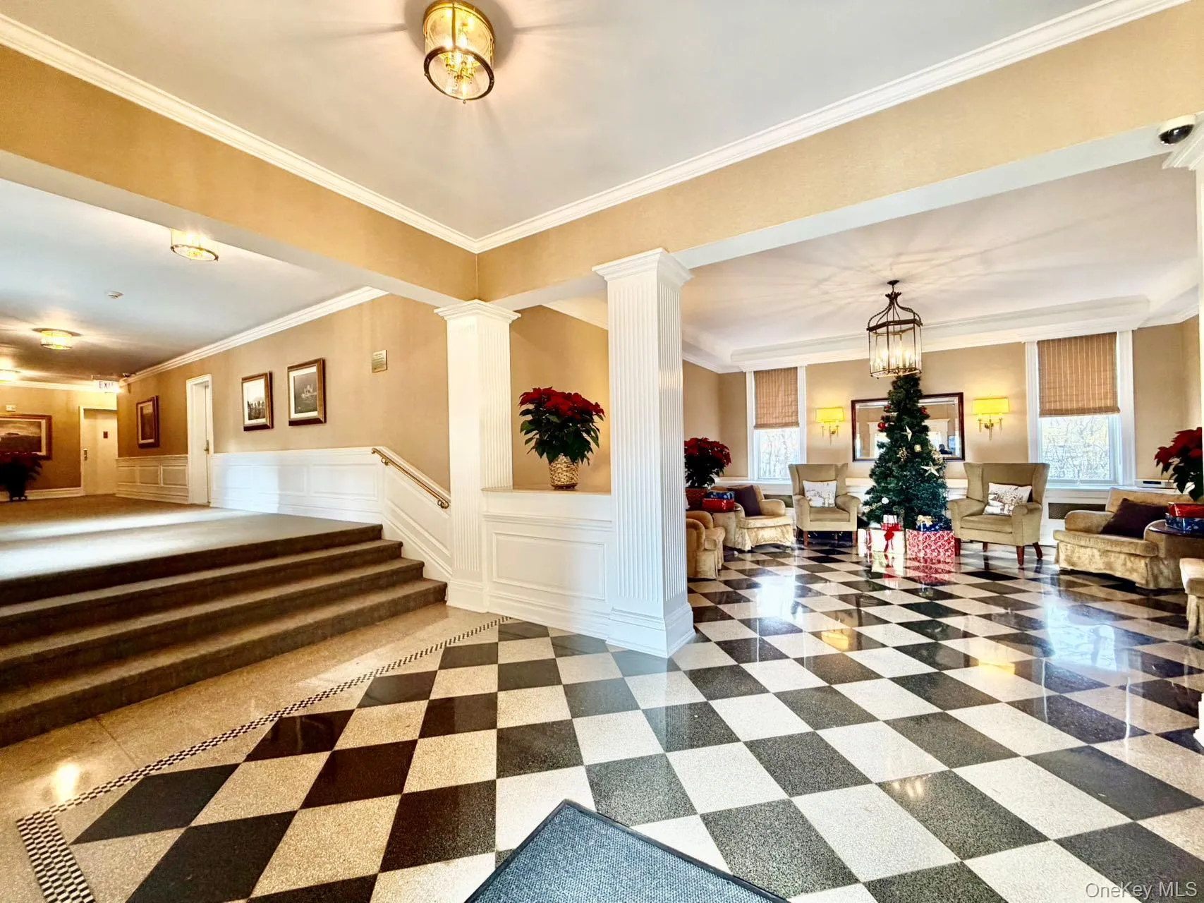 Lobby featuring a decorative wall, crown molding, and a wainscoted wall Lobby featuring a decorative wall, crown molding, and a wainscoted wall