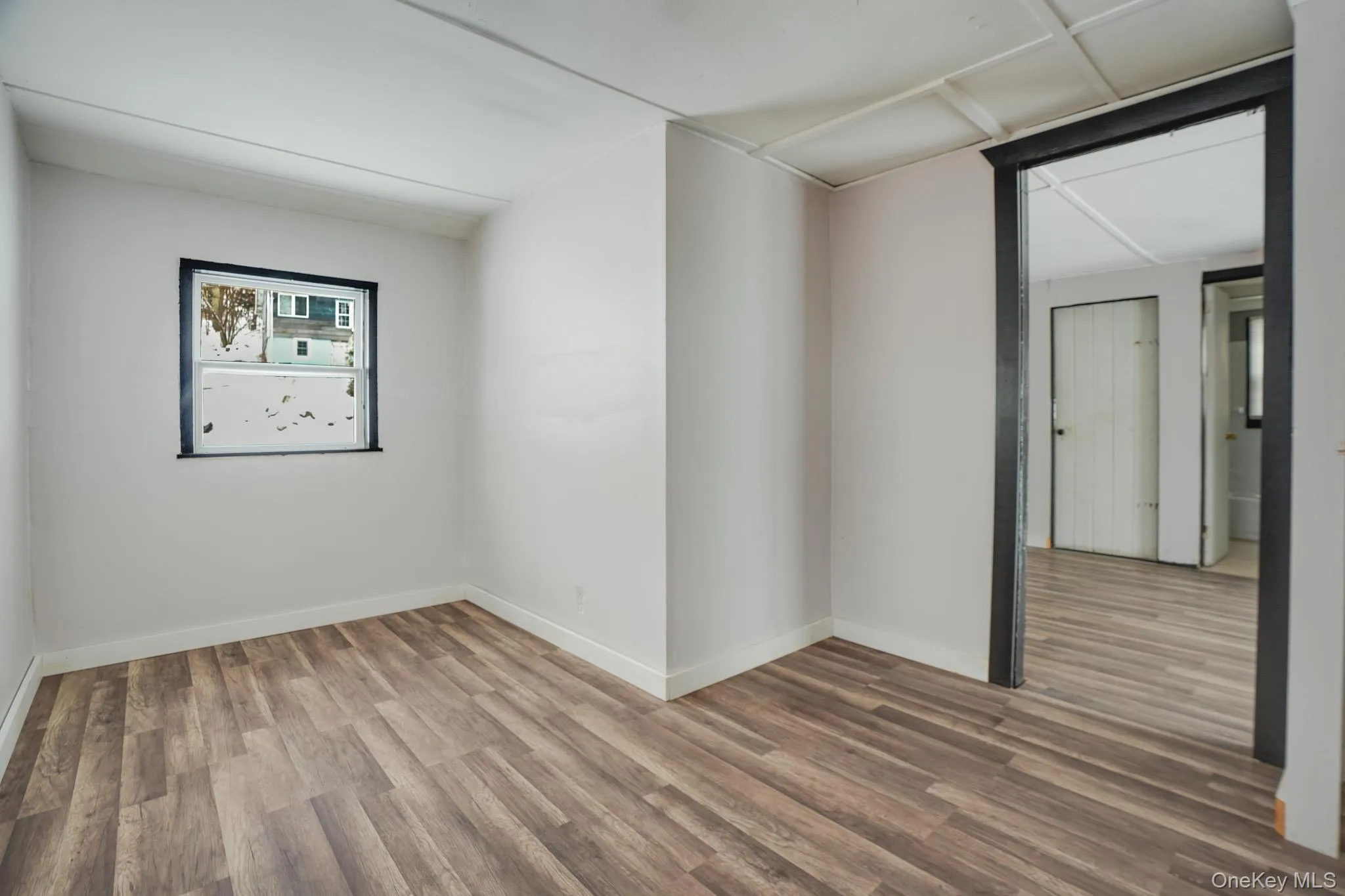 Empty room featuring wood finished floors and baseboards Empty room featuring wood finished floors and baseboards