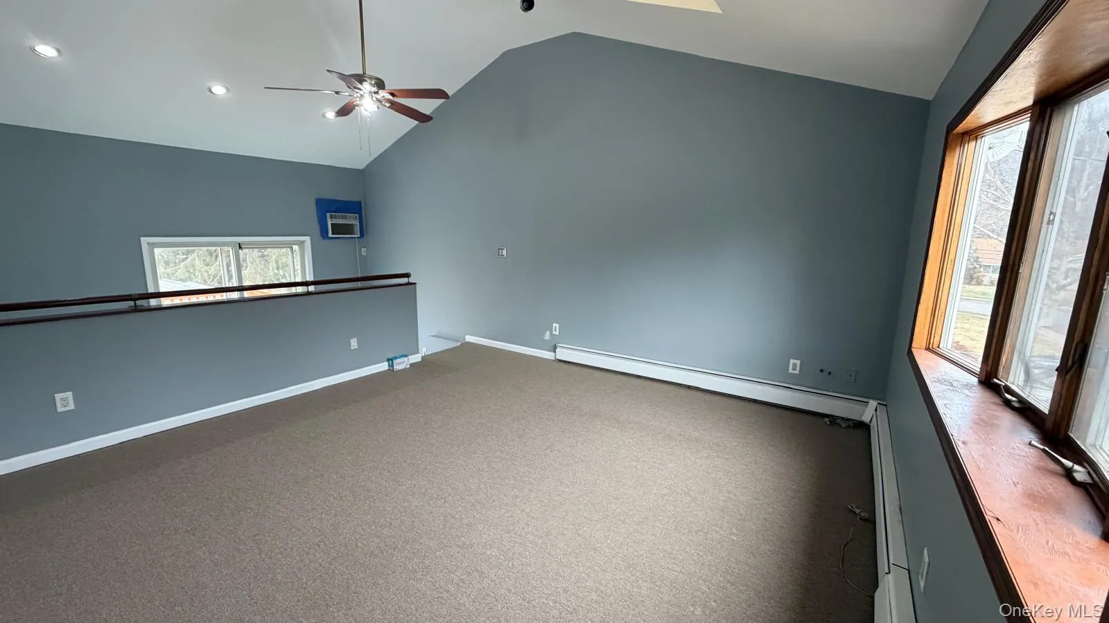 Spare room with baseboard heating, ceiling fan, a baseboard heating unit, carpet, and high vaulted ceiling Spare room with baseboard heating, ceiling fan, a baseboard heating unit, carpet, and high vaulted ceiling