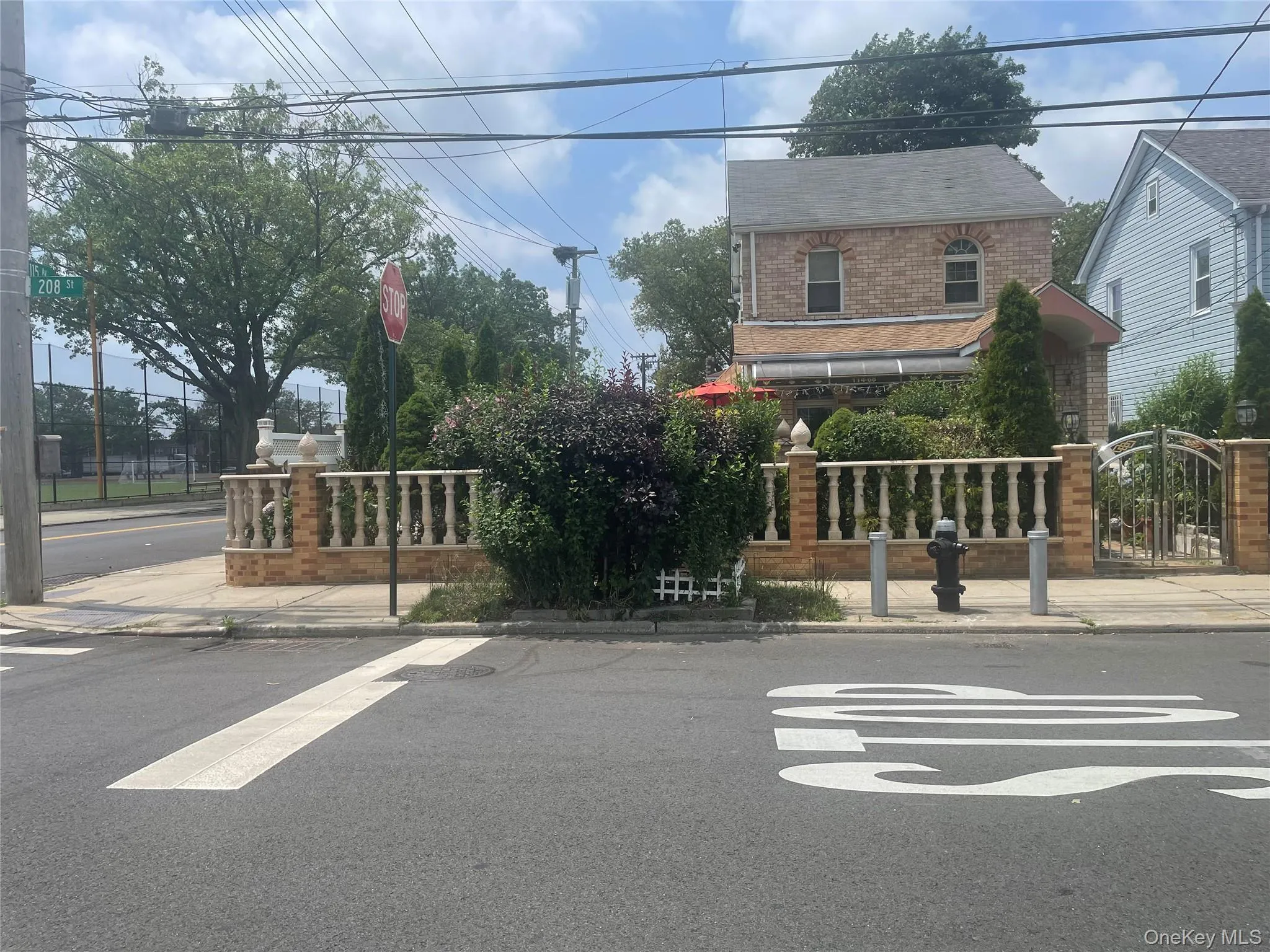 View of asphalt road with sidewalks, curbs, a gate, and traffic signs View of asphalt road with sidewalks, curbs, a gate, and traffic signs