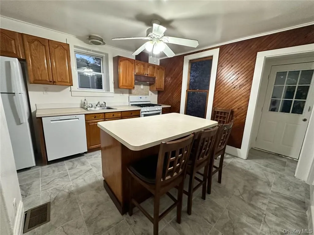 Kitchen with island, dishwasher, oven and refrigerator. Kitchen with island, dishwasher, oven and refrigerator.