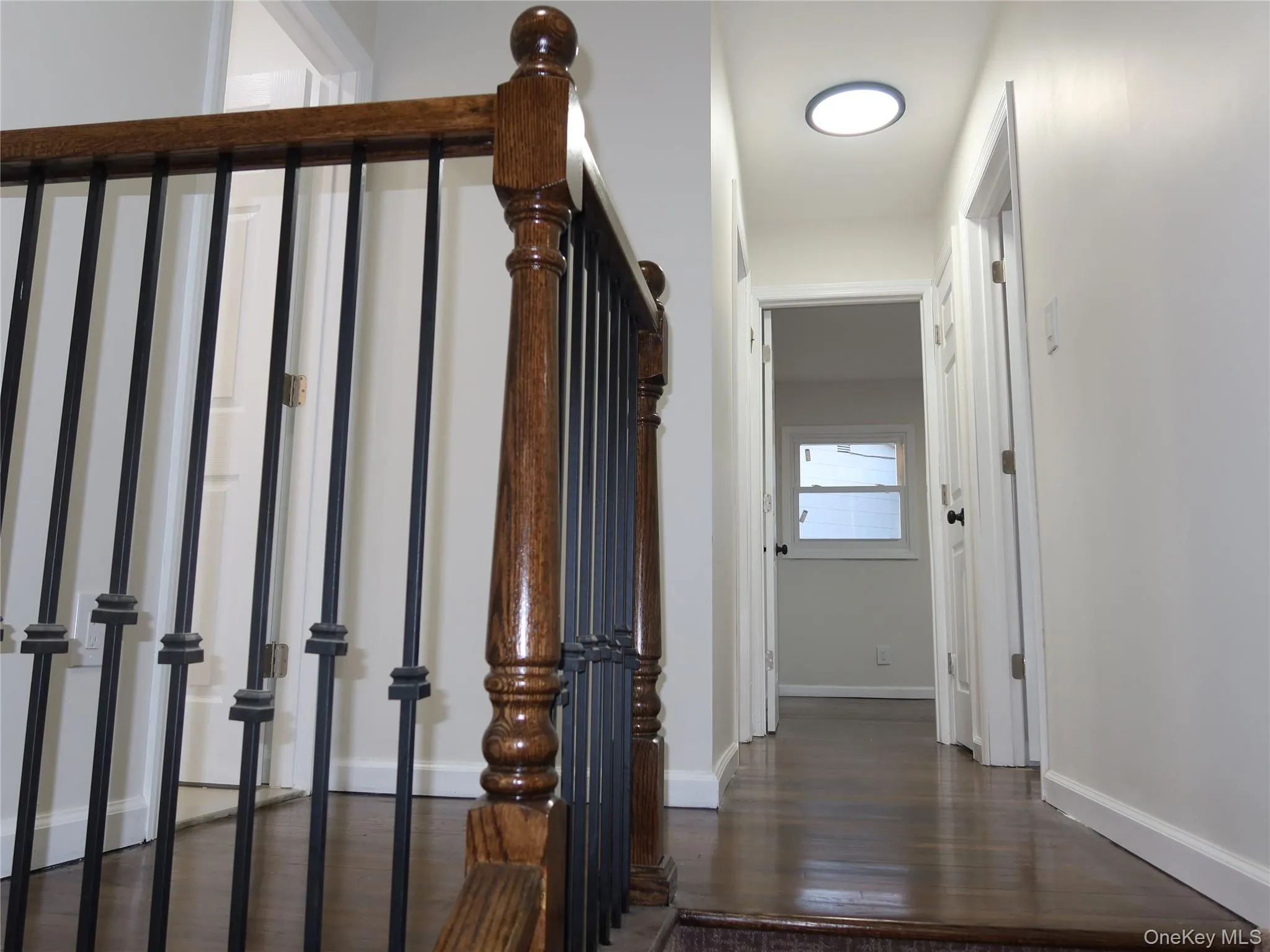 Hallway featuring dark wood-style floors and baseboards Hallway featuring dark wood-style floors and baseboards