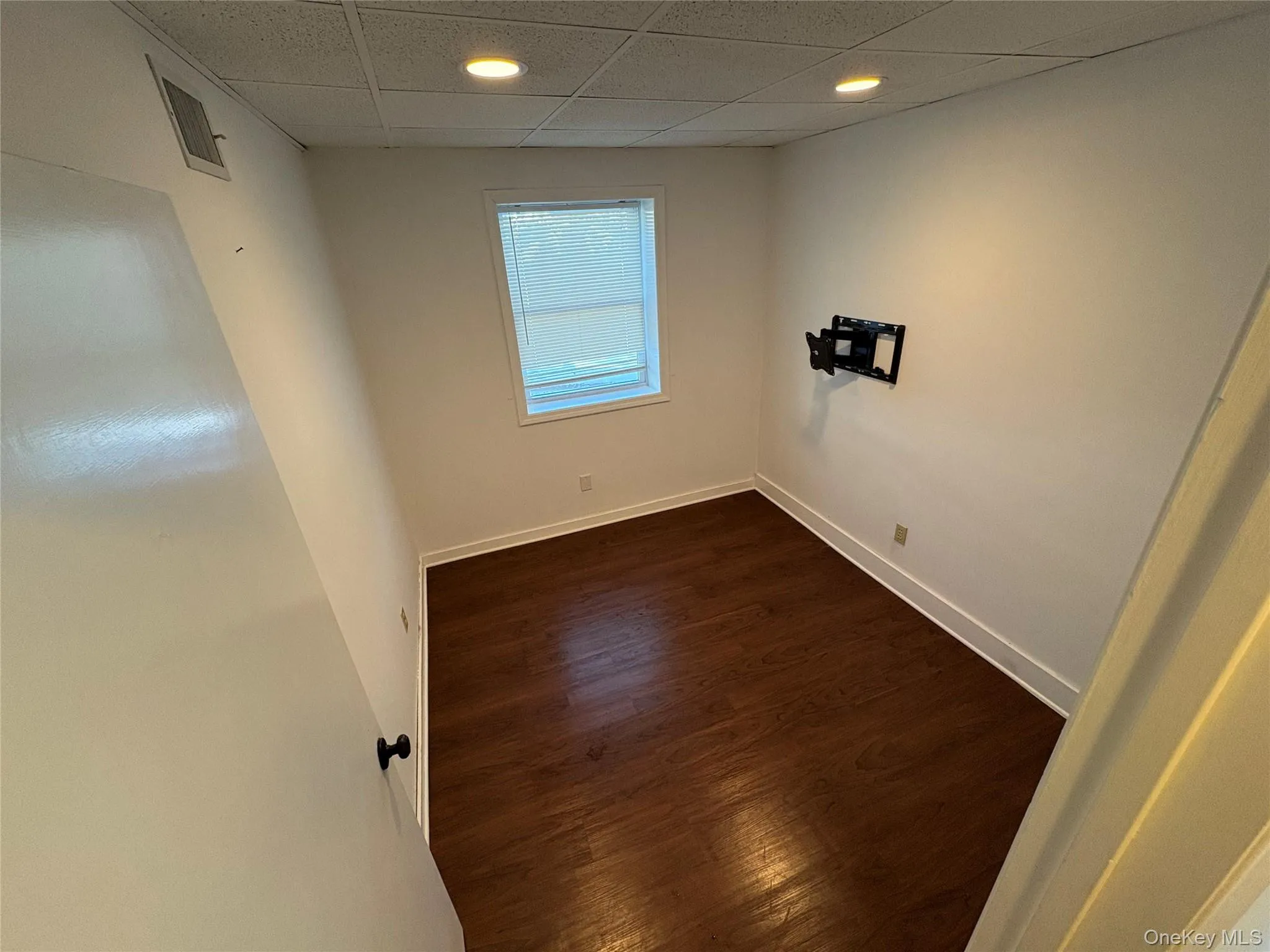 Spare room featuring a drop ceiling, dark wood-style floors, and recessed lighting Spare room featuring a drop ceiling, dark wood-style floors, and recessed lighting