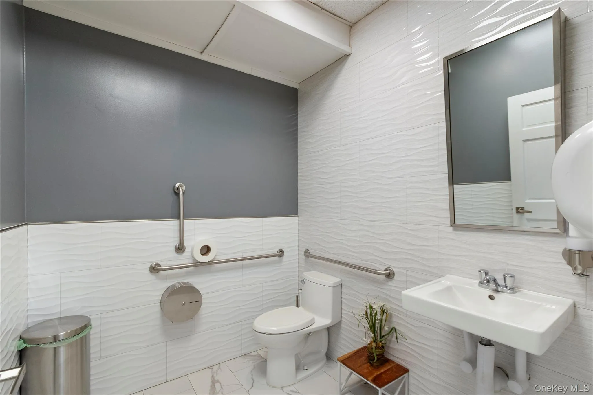 Half bathroom featuring toilet and tile walls Half bathroom featuring toilet and tile walls