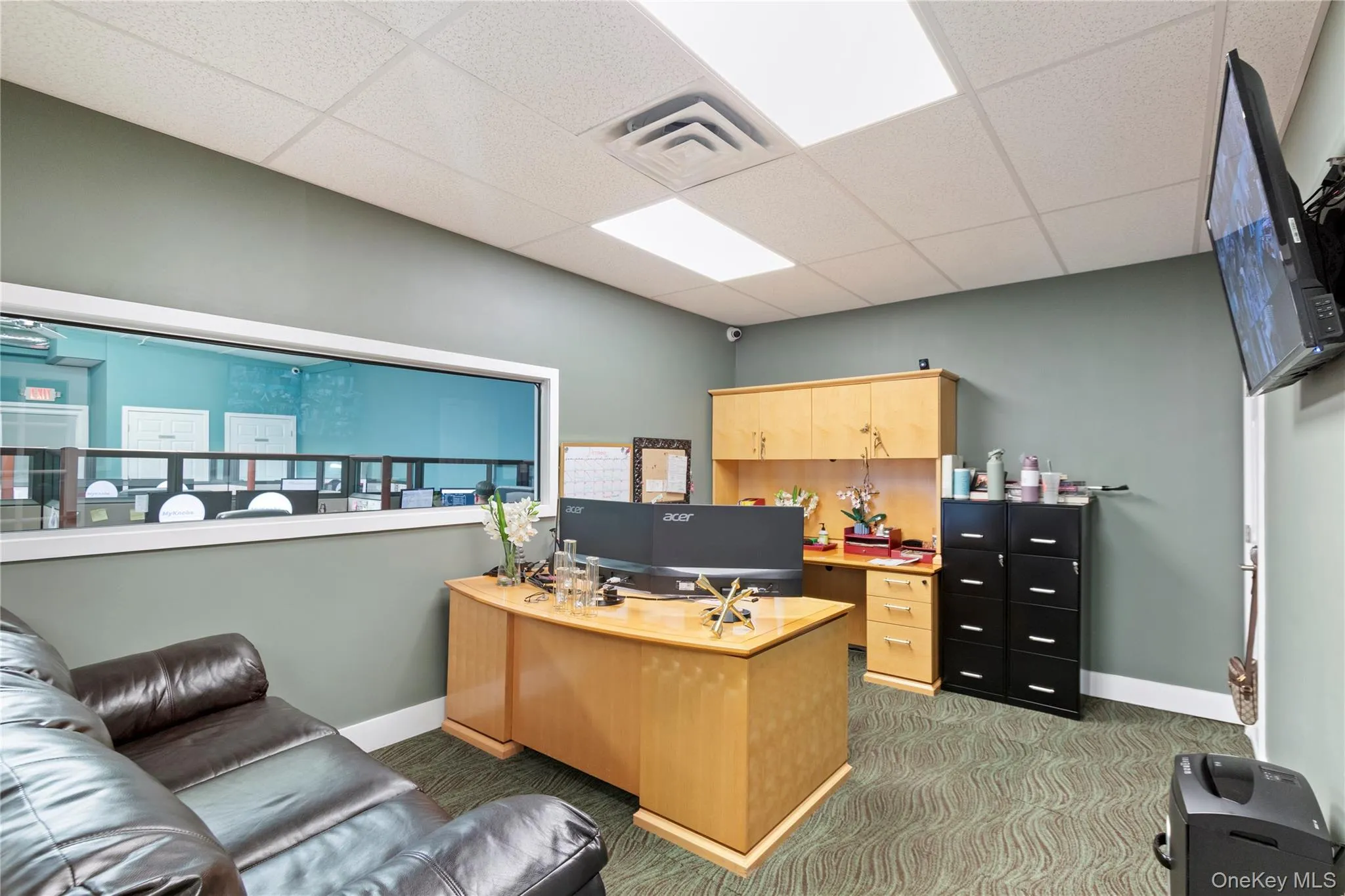 Office with light carpet and a paneled ceiling Office with light carpet and a paneled ceiling
