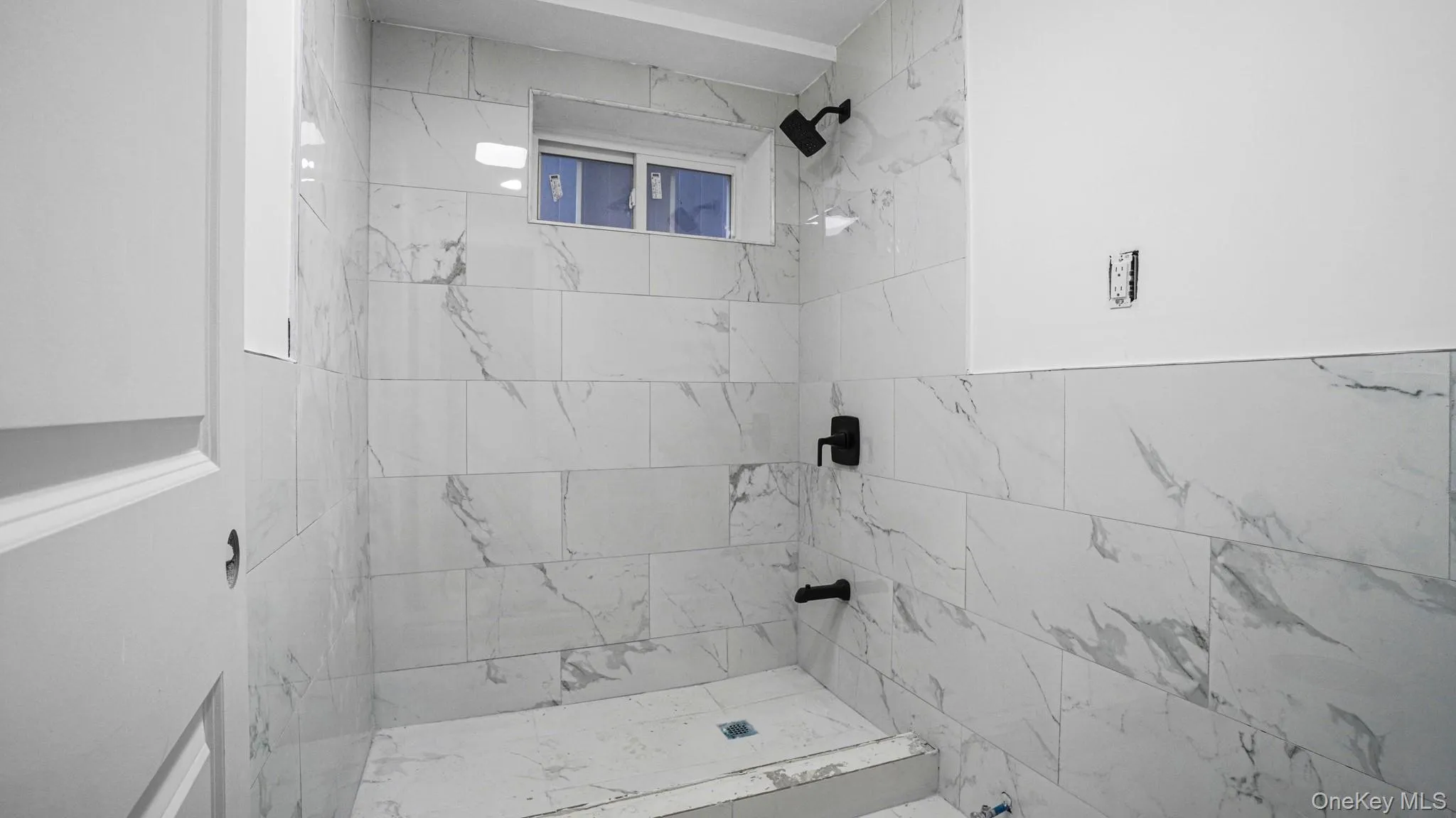 Full bath featuring a marble finish shower Full bath featuring a marble finish shower