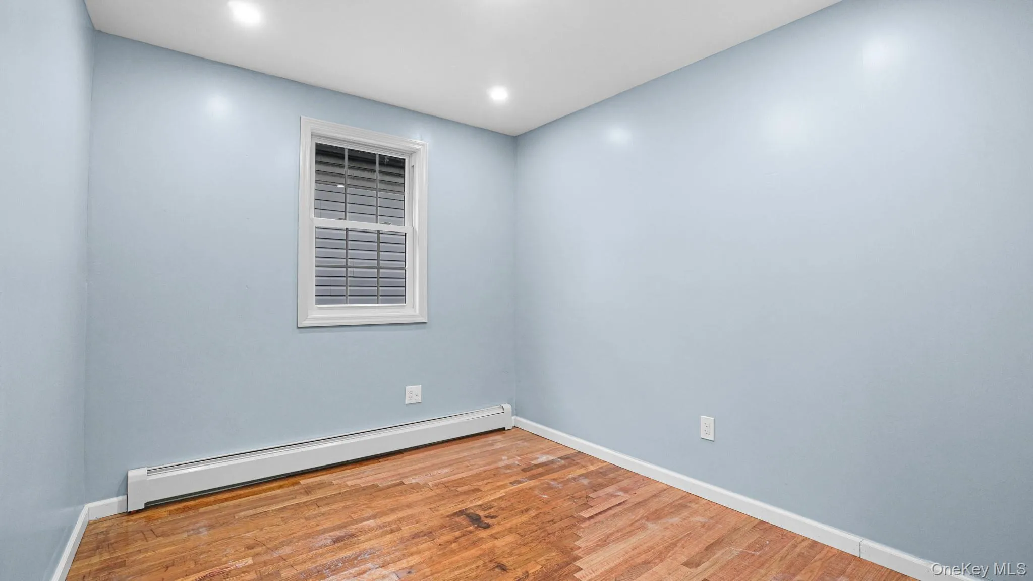 Spare room with a baseboard heating unit, wood finished floors, and recessed lighting Spare room with a baseboard heating unit, wood finished floors, and recessed lighting