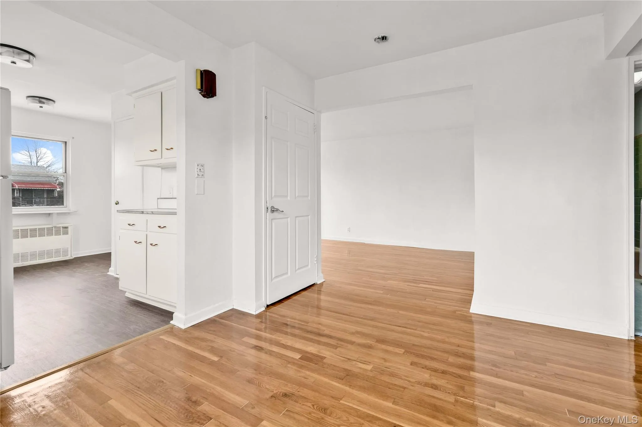 Unfurnished room with light wood-type flooring and radiator Unfurnished room with light wood-type flooring and radiator