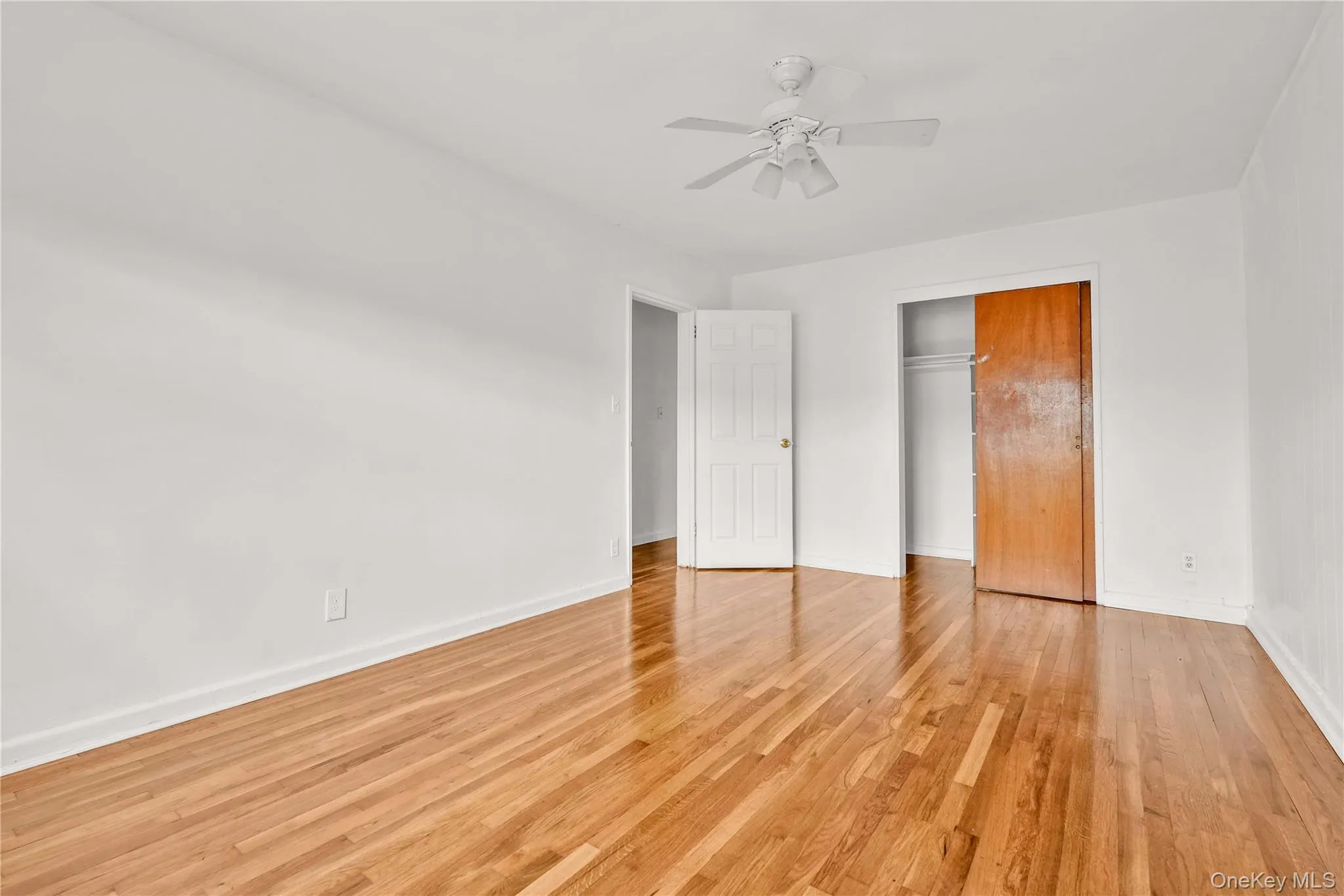 Unfurnished bedroom with a closet, light wood-style floors, and a ceiling fan Unfurnished bedroom with a closet, light wood-style floors, and a ceiling fan