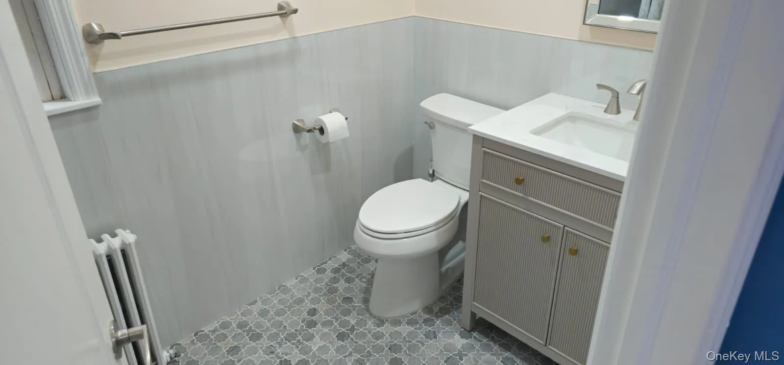 Bathroom with wainscoting, vanity, radiator heating unit, and tile patterned flooring Bathroom with wainscoting, vanity, radiator heating unit, and tile patterned flooring