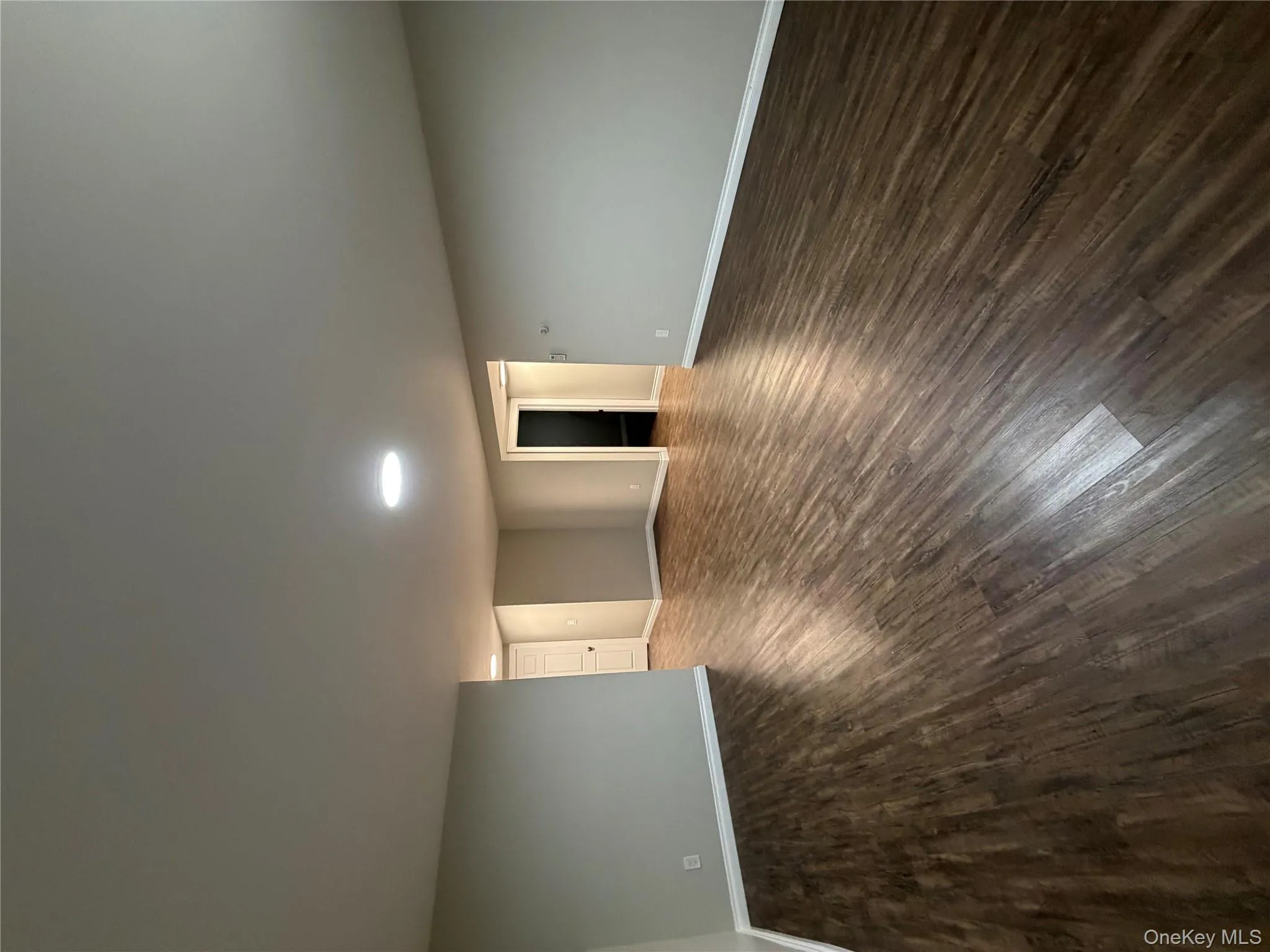 Spare room featuring baseboards and dark wood-style floors Spare room featuring baseboards and dark wood-style floors