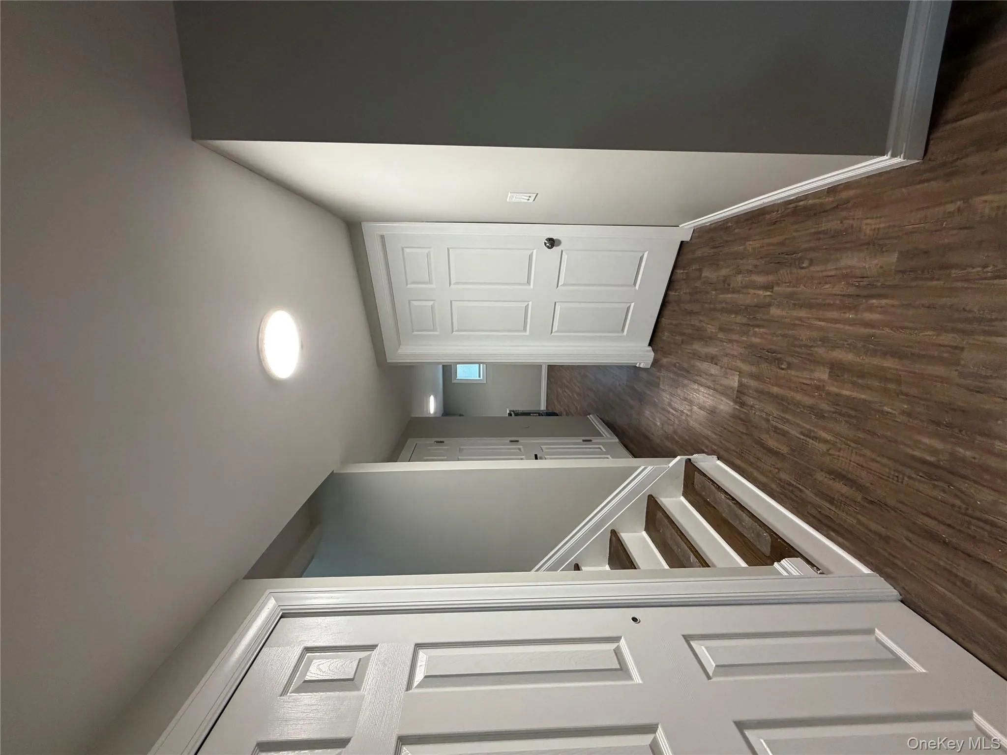 Hallway with dark wood-style flooring and stairway Hallway with dark wood-style flooring and stairway
