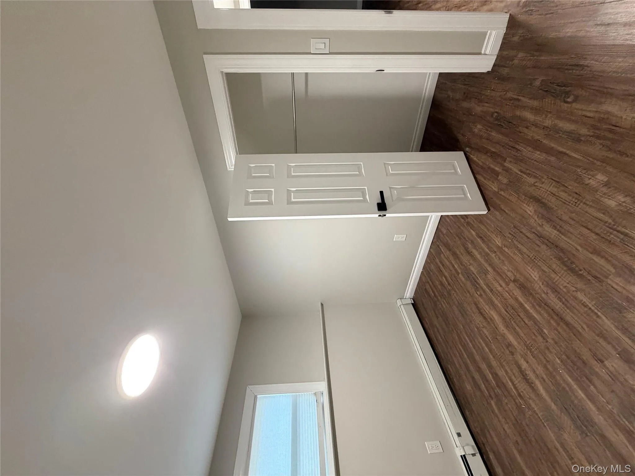 Unfurnished bedroom featuring baseboard heating, dark wood-style floors, and a closet Unfurnished bedroom featuring baseboard heating, dark wood-style floors, and a closet