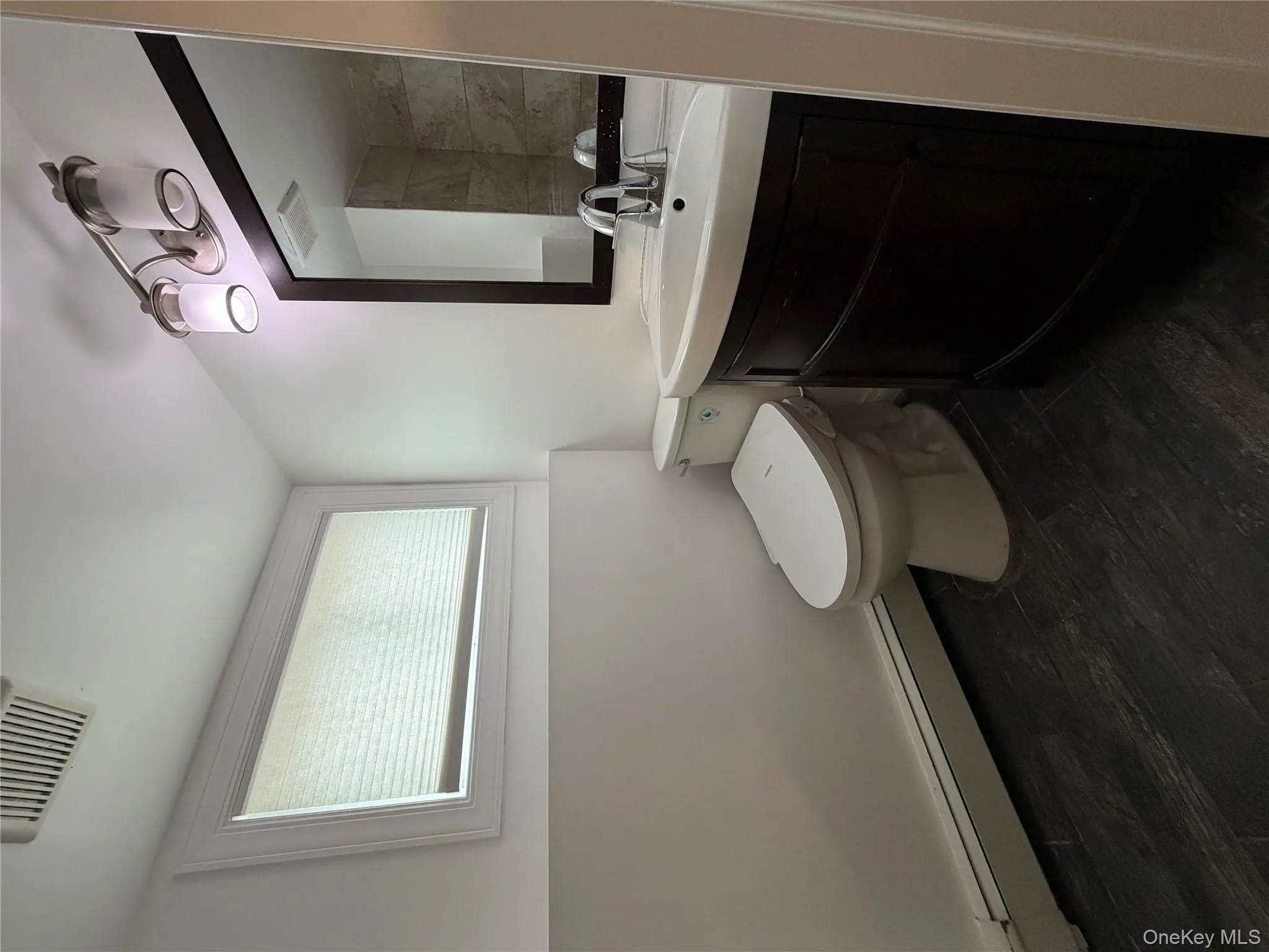 Bathroom with a baseboard radiator, vanity, and dark wood-style flooring Bathroom with a baseboard radiator, vanity, and dark wood-style flooring
