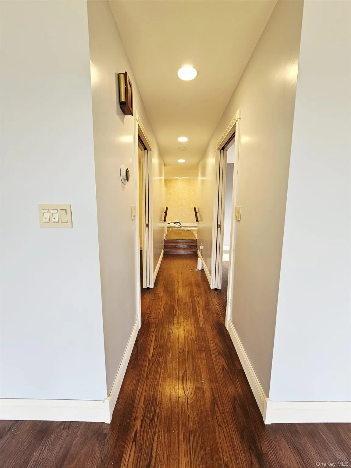 Hallway with recessed lighting and dark wood-type flooring Hallway with recessed lighting and dark wood-type flooring
