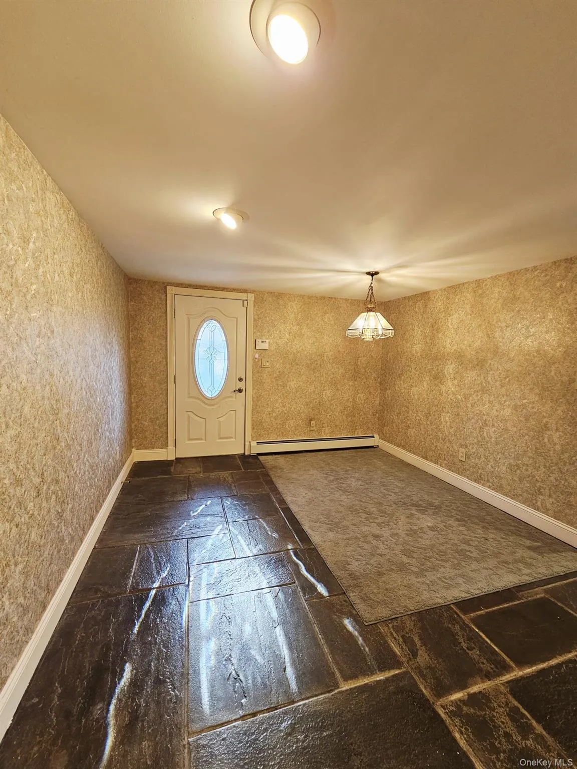 Entrance foyer with wallpapered walls and a baseboard radiator Entrance foyer with wallpapered walls and a baseboard radiator