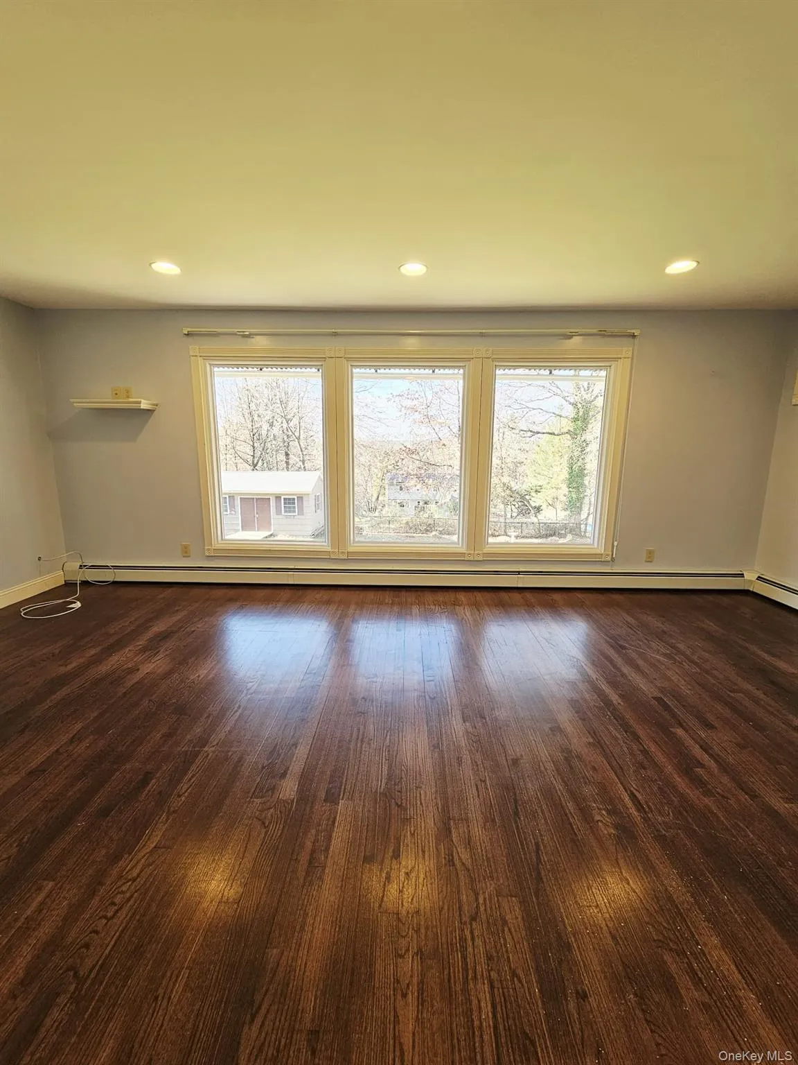 Spare room featuring dark wood-style flooring, recessed lighting, and a baseboard radiator Spare room featuring dark wood-style flooring, recessed lighting, and a baseboard radiator