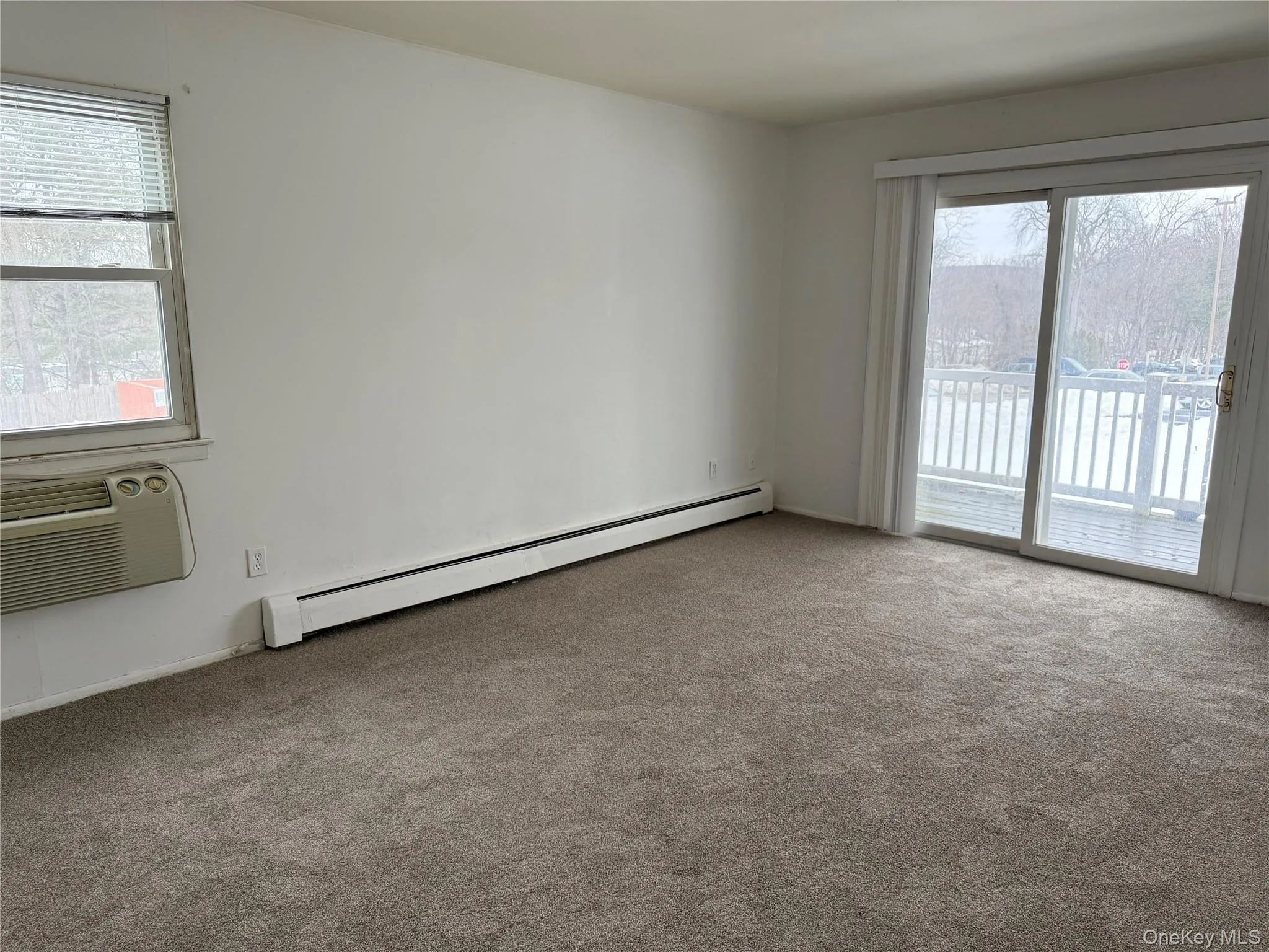 Primary bedroom with attached half bath and sliding doors leading to a private balcony. Primary bedroom with attached half bath and sliding doors leading to a private balcony.