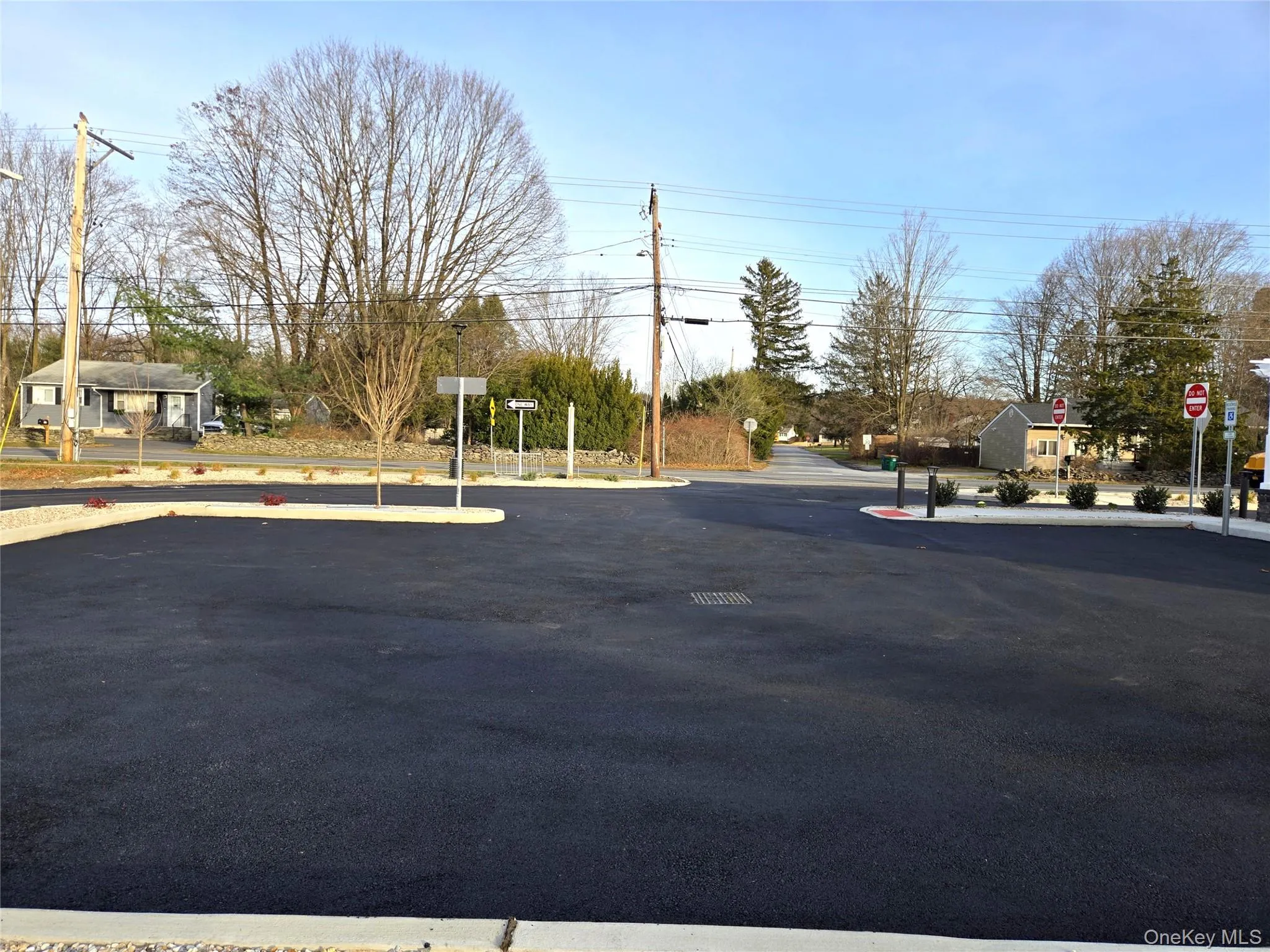 View of asphalt road with traffic signs, curbs, and street lights View of asphalt road with traffic signs, curbs, and street lights