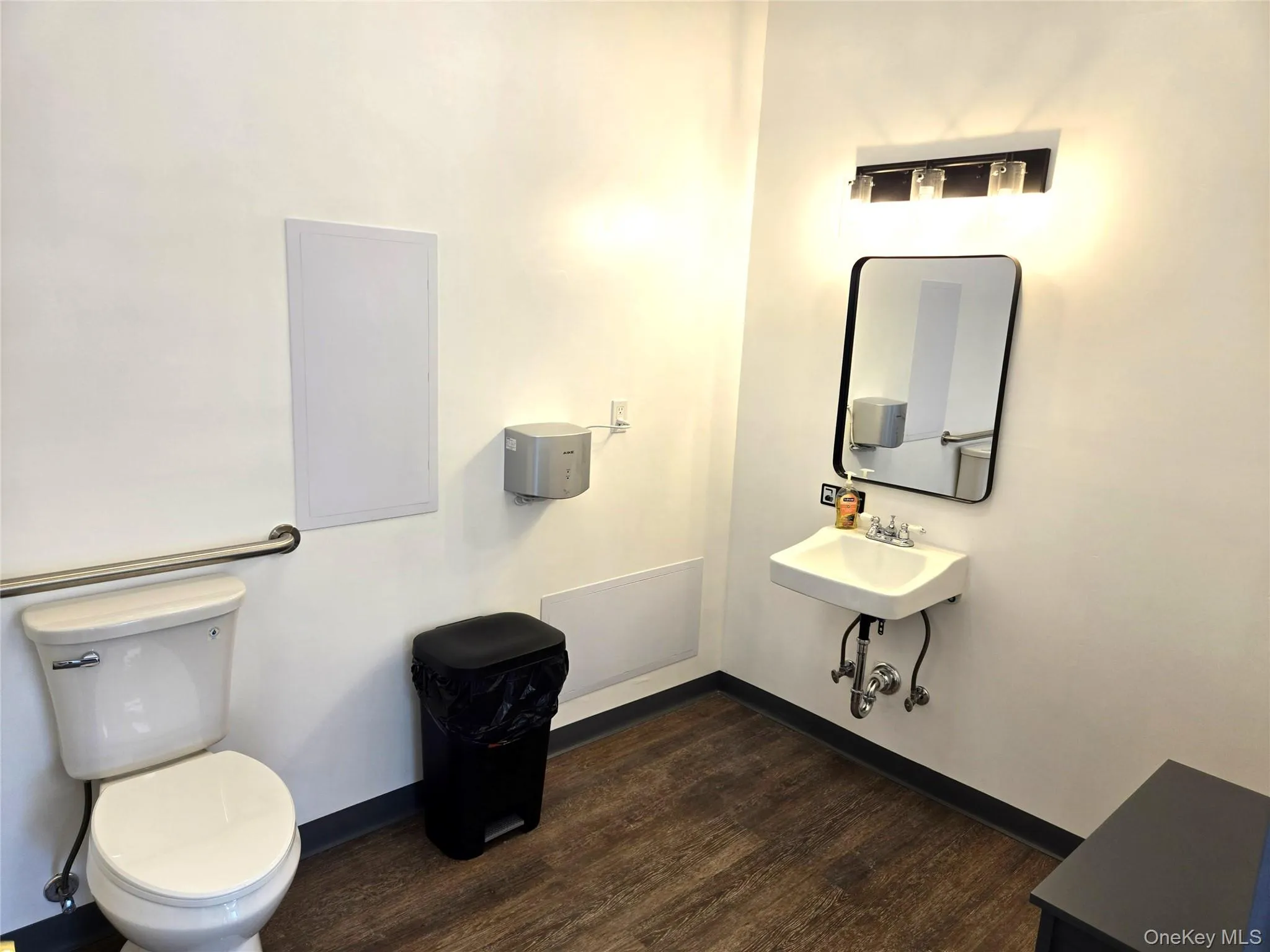 Half bathroom with baseboards and dark wood-type flooring Half bathroom with baseboards and dark wood-type flooring