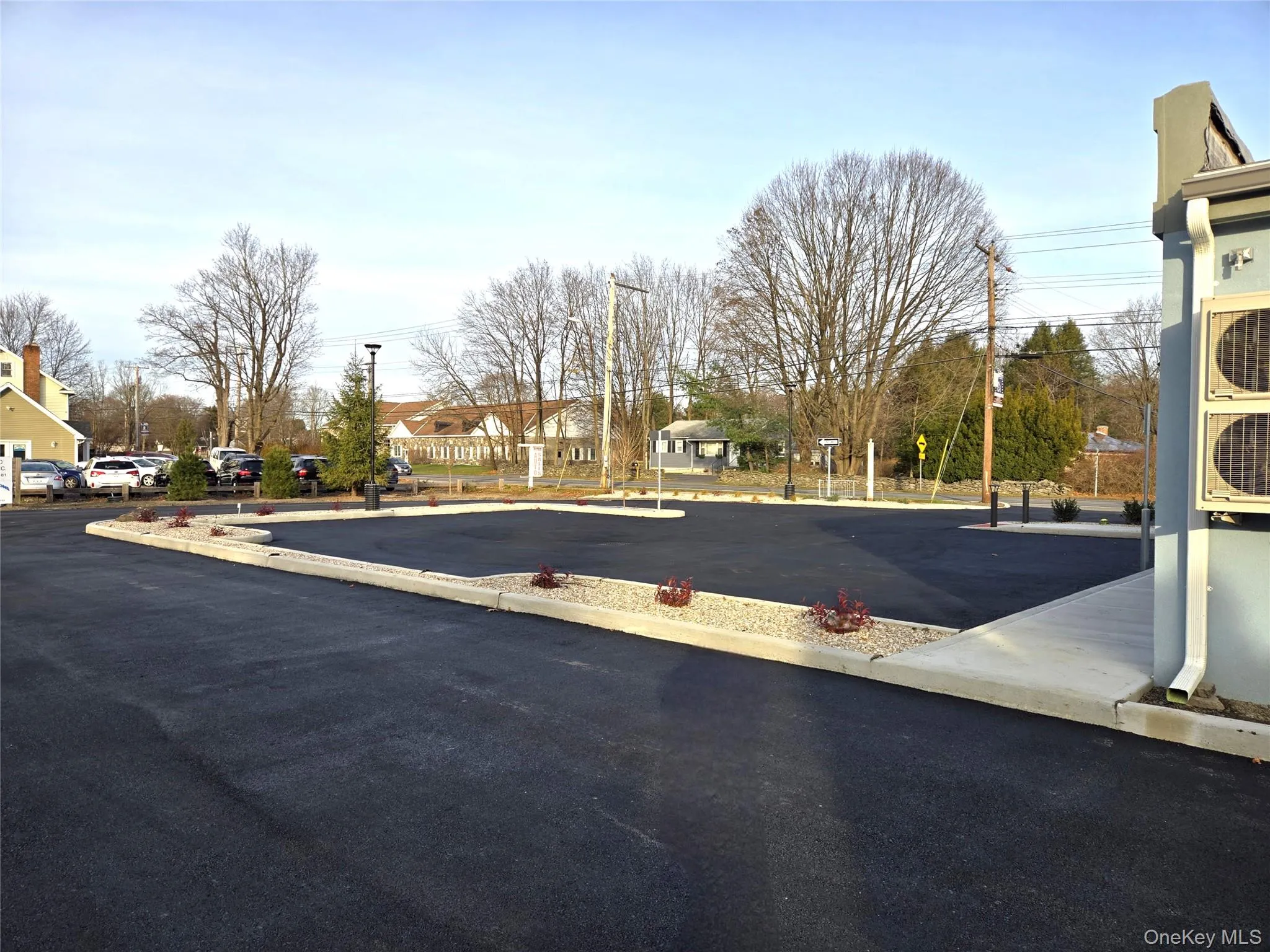 View of asphalt road with a residential view and street lighting View of asphalt road with a residential view and street lighting