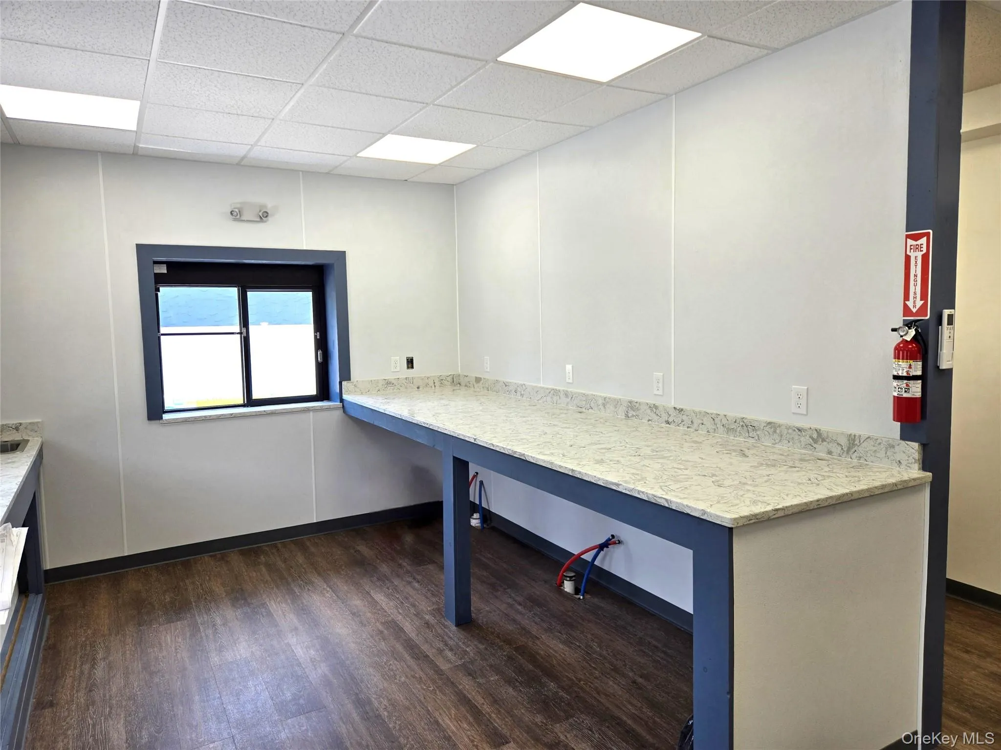 Unfurnished office featuring dark wood-style floors and a drop ceiling Unfurnished office featuring dark wood-style floors and a drop ceiling