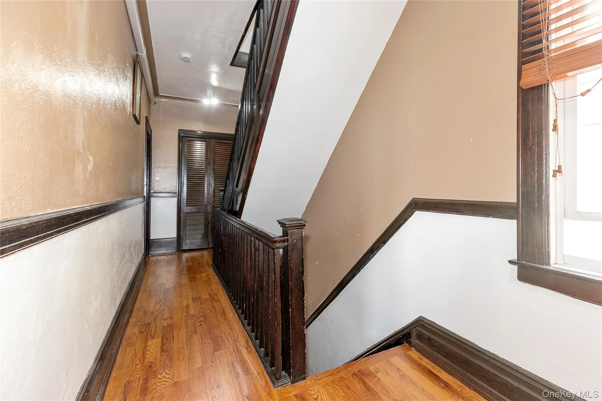Hall featuring wood finished floors and an upstairs landing Hall featuring wood finished floors and an upstairs landing
