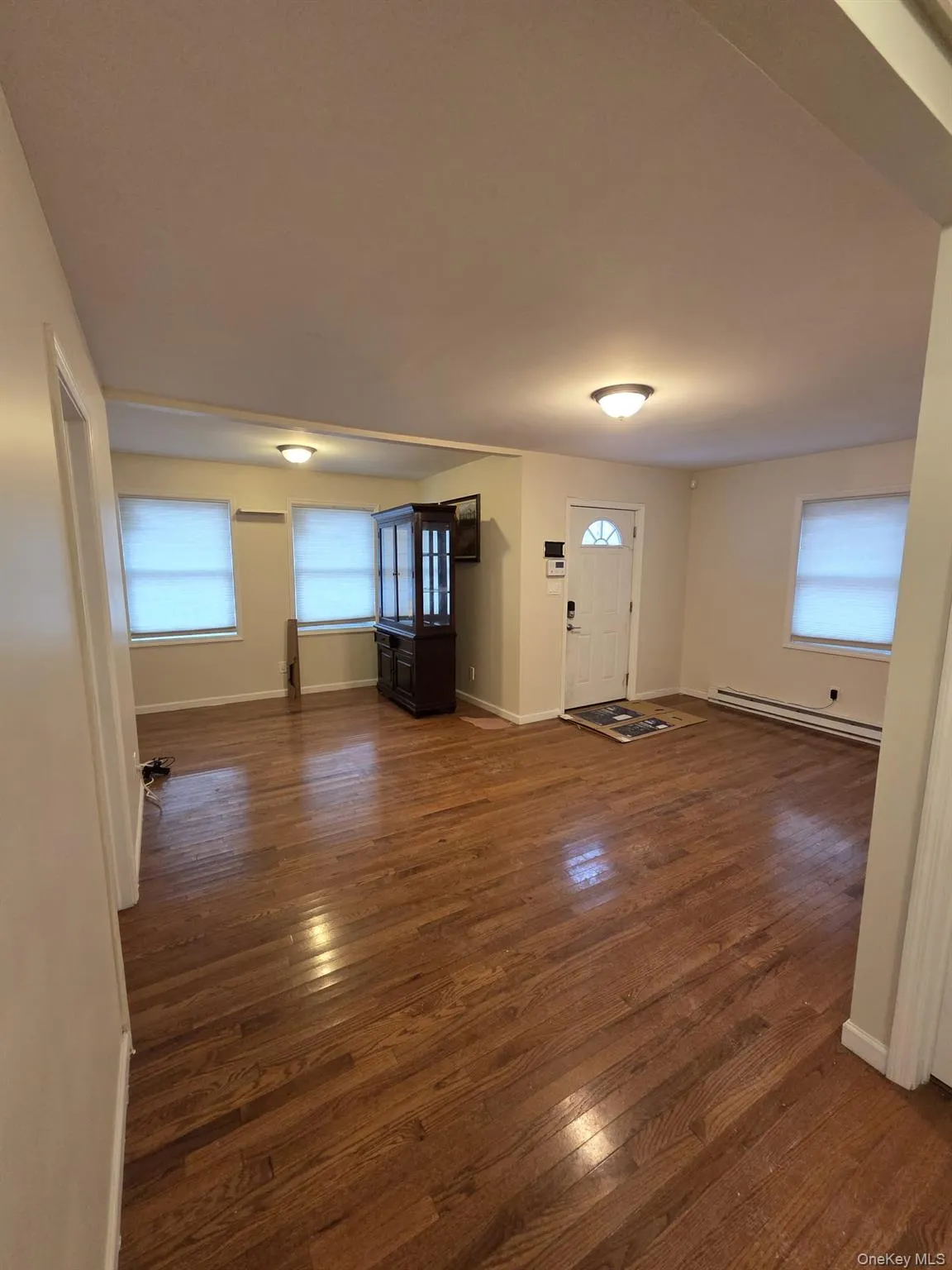 Entrance foyer with dark wood-style floors and a baseboard heating unit Entrance foyer with dark wood-style floors and a baseboard heating unit