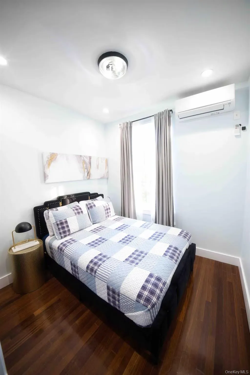 Bedroom featuring a wall mounted AC, dark wood-type flooring, and recessed lighting Bedroom featuring a wall mounted AC, dark wood-type flooring, and recessed lighting