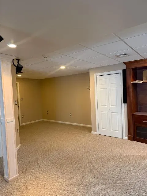Below grade area featuring carpet floors, recessed lighting, and a paneled ceiling Below grade area featuring carpet floors, recessed lighting, and a paneled ceiling